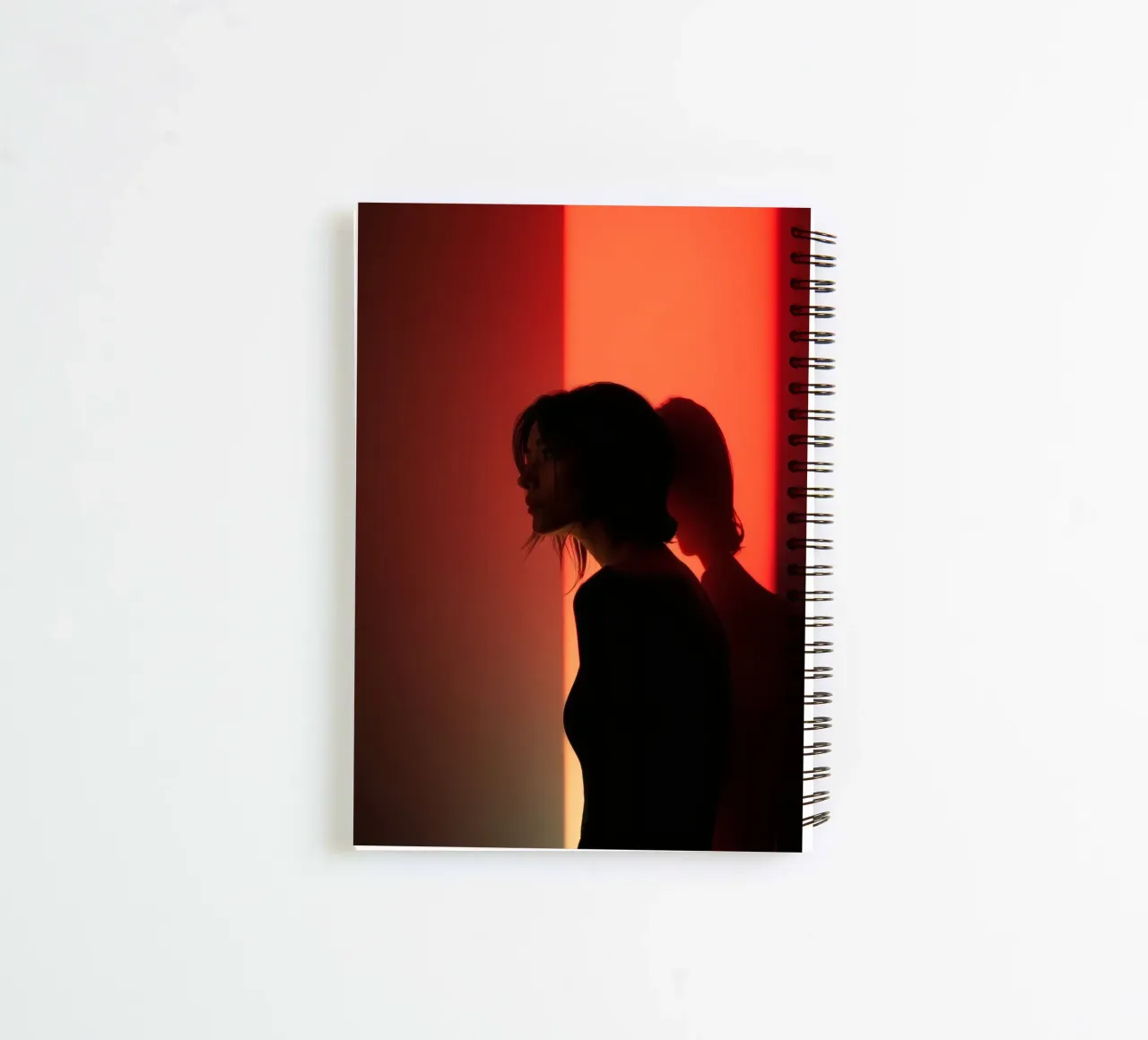 Silhouette of a woman in dim light with colorful background spiral notebook by DesignDoodle