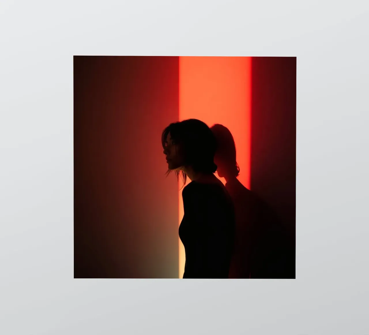 Silhouette d'une femme dans une lumière tamisée sur fond coloré autocollant de DesignDoodle