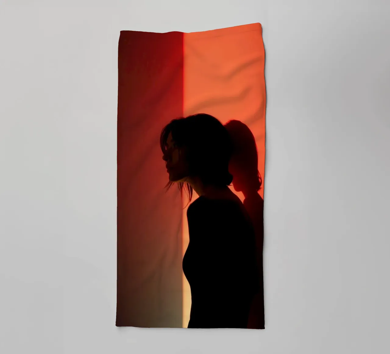 Silhouette d'une femme dans une lumière tamisée sur fond coloré serviette de bain de DesignDoodle