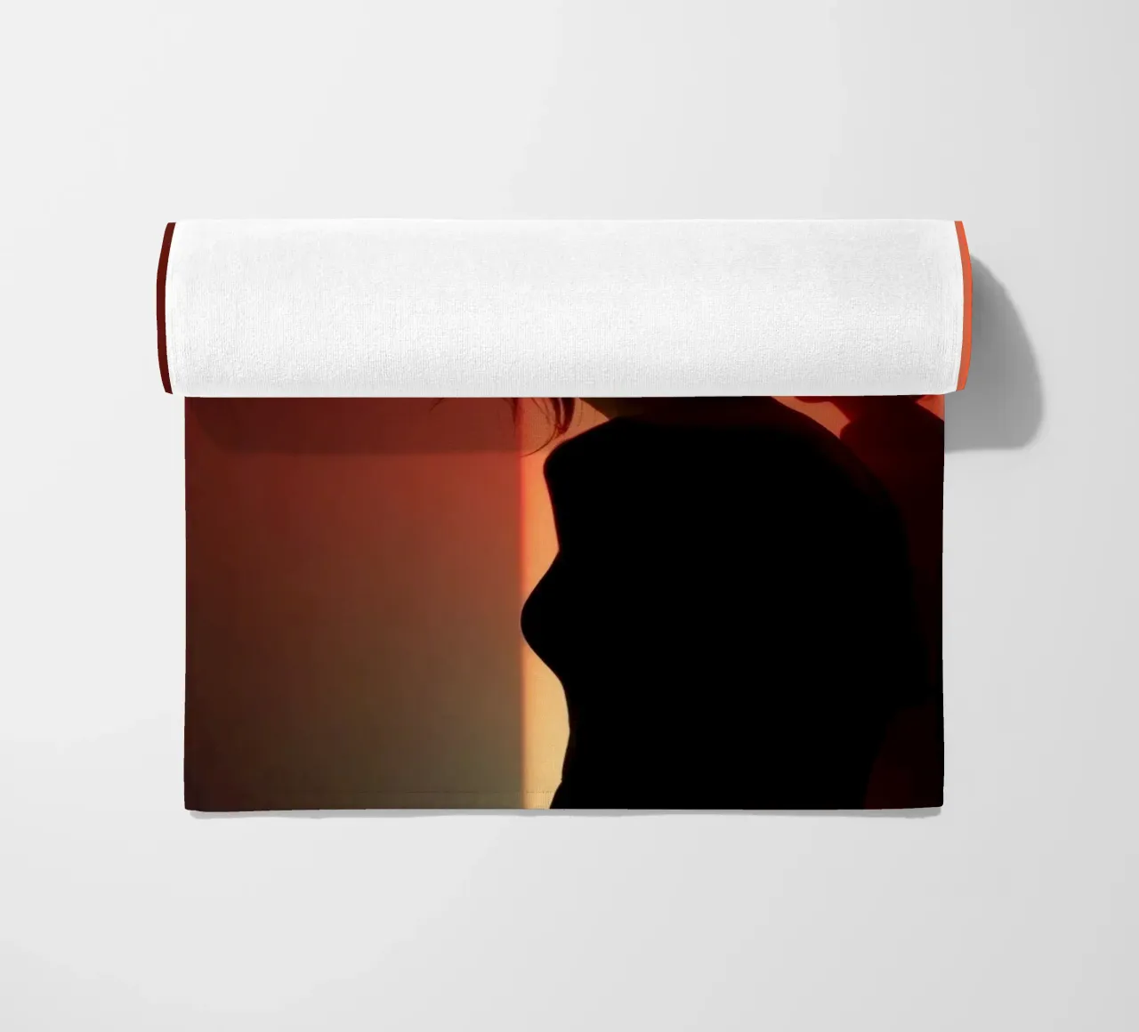 Silhouette d'une femme dans une lumière tamisée sur fond coloré serviette de plage de DesignDoodle