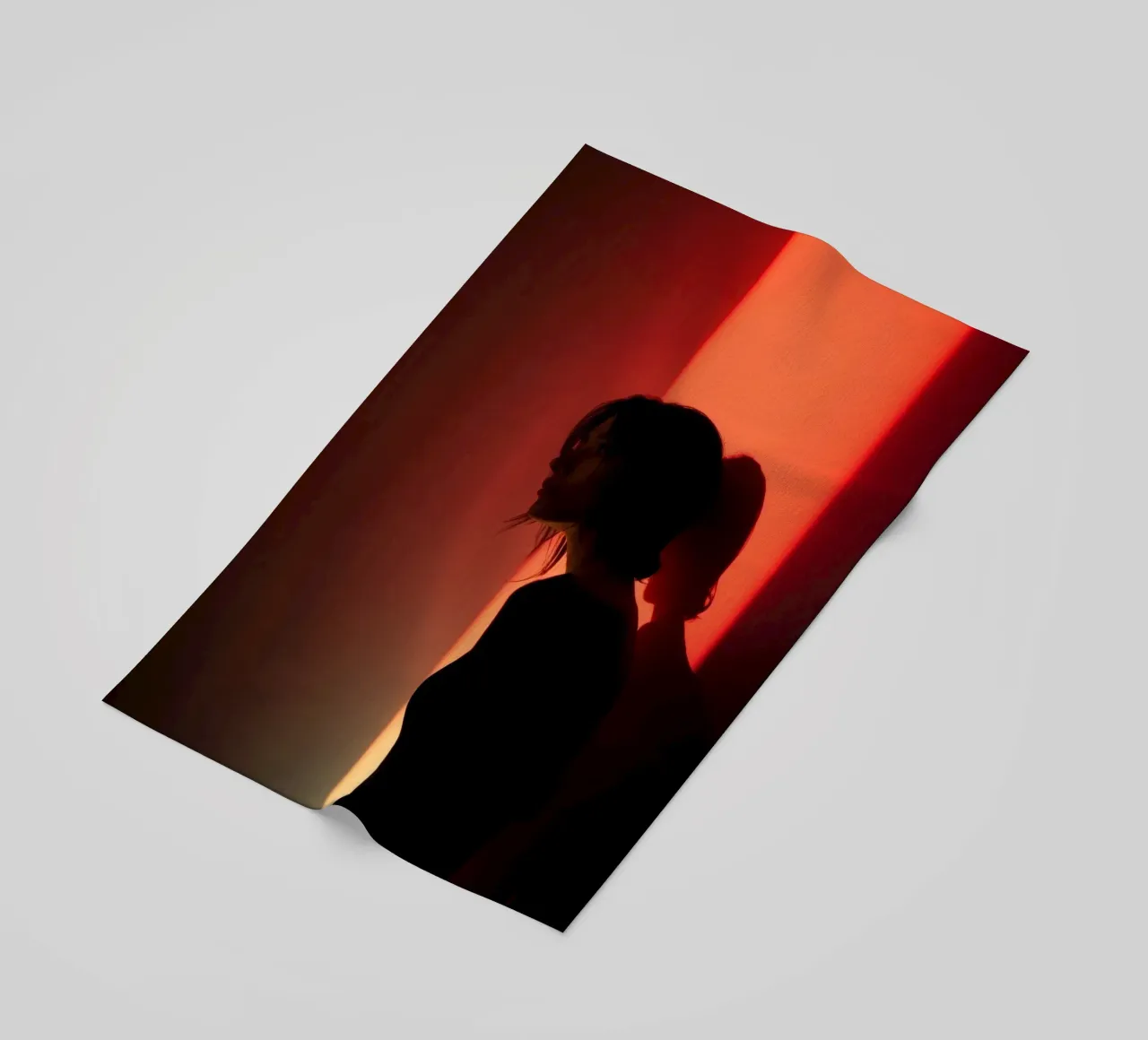 Silhouette d'une femme dans une lumière tamisée sur fond coloré serviette de plage de DesignDoodle