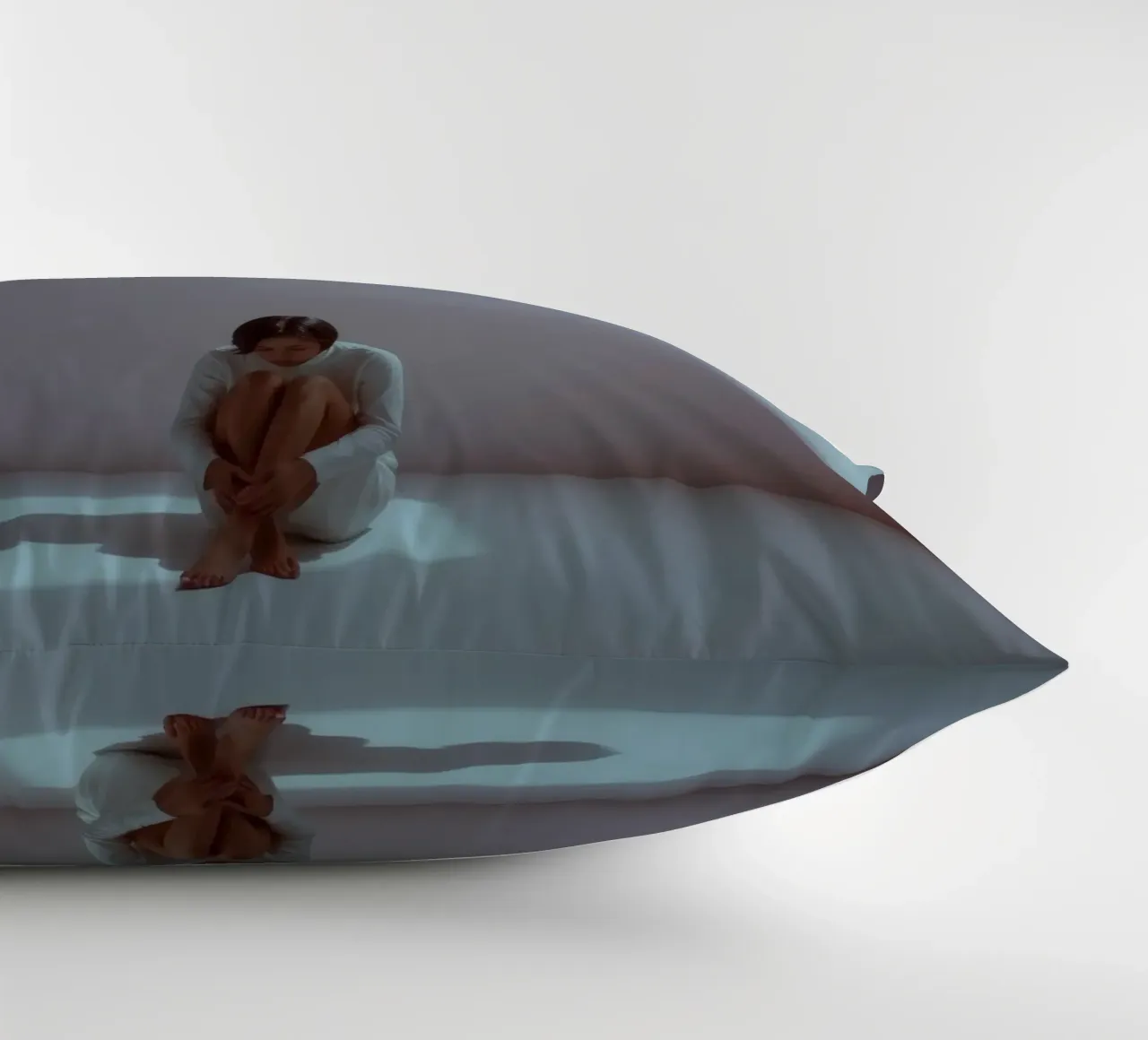Young woman sits thoughtfully in dimly lit space, reflecting decorative cushion by DesignDoodle