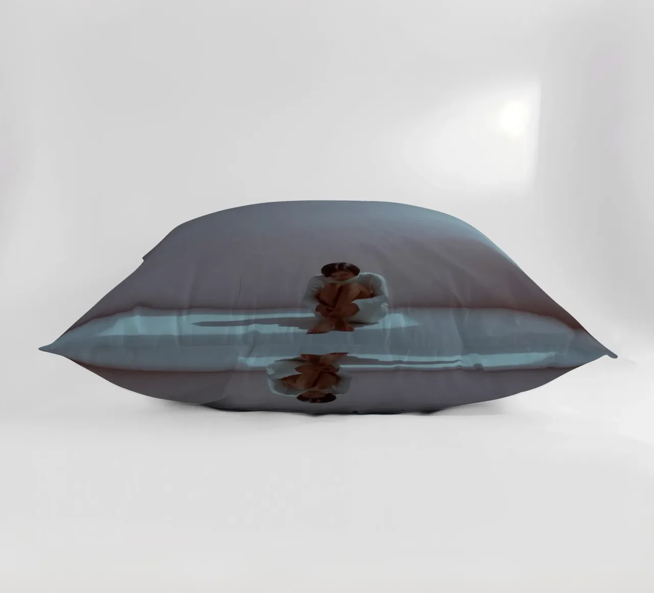 Young woman sits thoughtfully in dimly lit space, reflecting decorative cushion by DesignDoodle