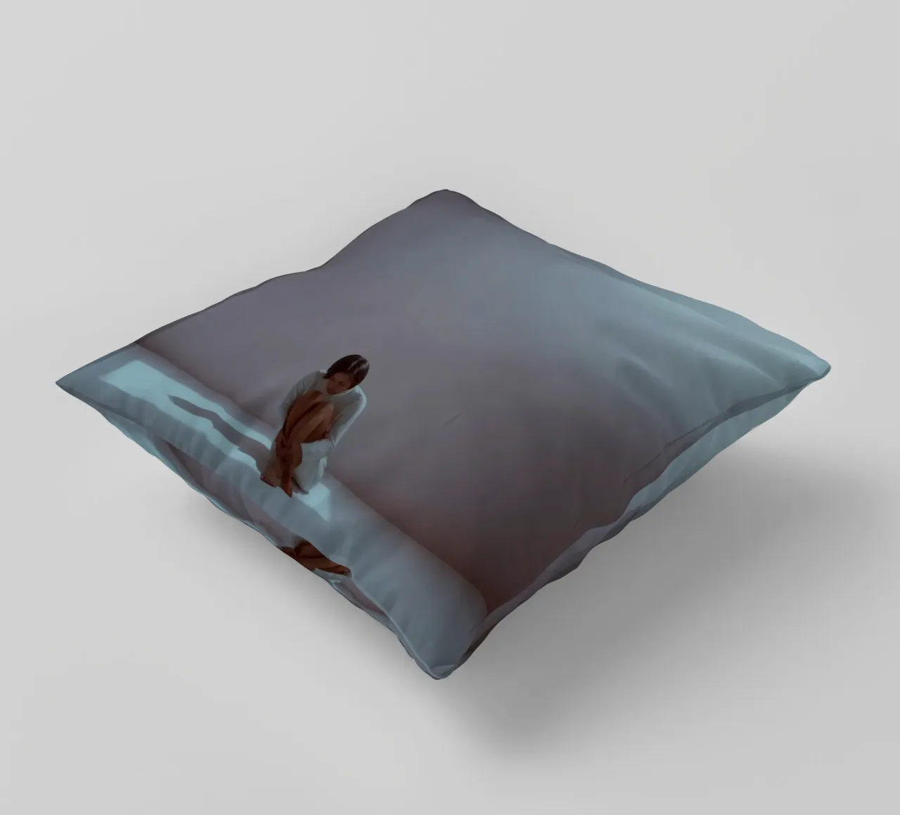Young woman sits thoughtfully in dimly lit space, reflecting decorative cushion by DesignDoodle