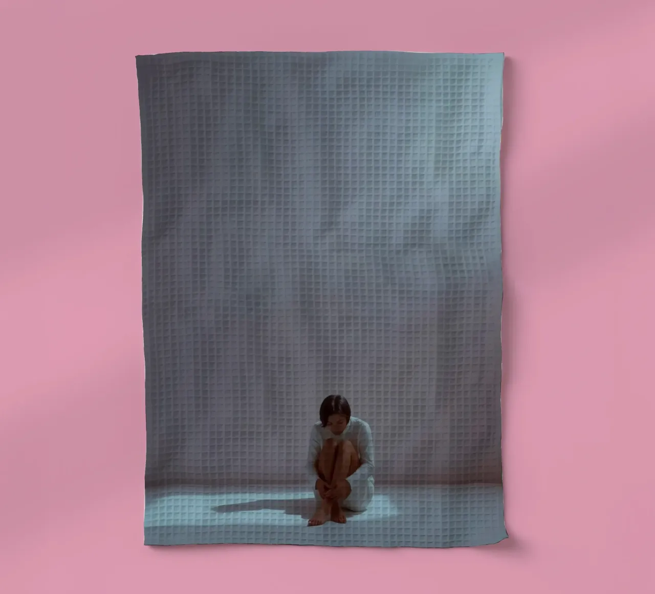 Une jeune femme est assise, pensive, dans un espace faiblement éclairé, en train de réfléchir. torchon de DesignDoodle