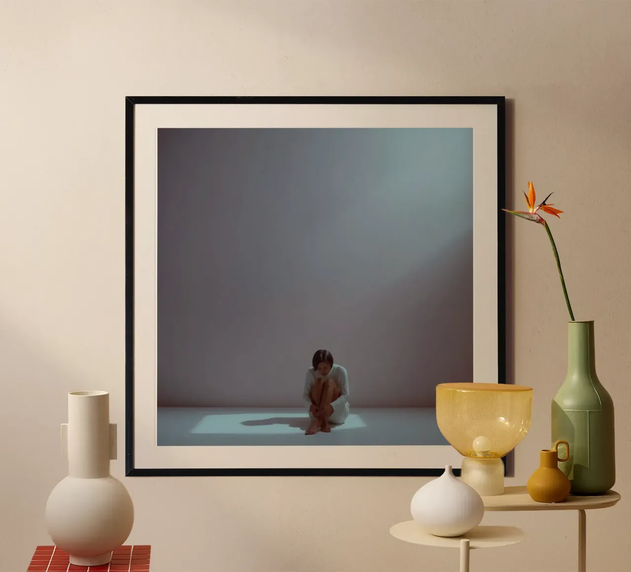 Una giovane donna siede pensierosa in uno spazio scarsamente illuminato, riflettendo poster con telaio in plastica da DesignDoodle