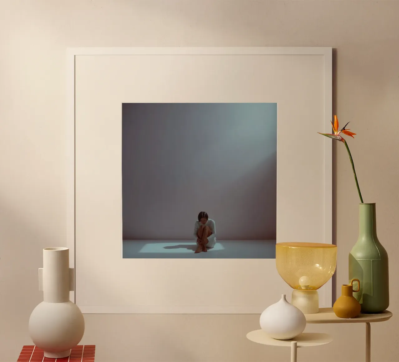 Una giovane donna siede pensierosa in uno spazio scarsamente illuminato, riflettendo poster con telaio in plastica da DesignDoodle