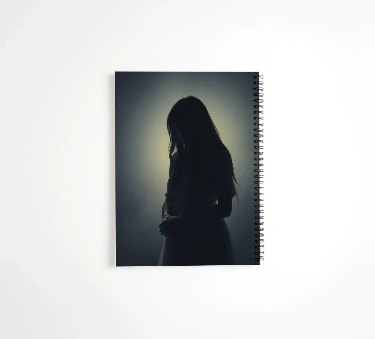Silhouette di una donna con i capelli lunghi in un'atmosfera di luce soffusa. diario ad anelli da DesignDoodle