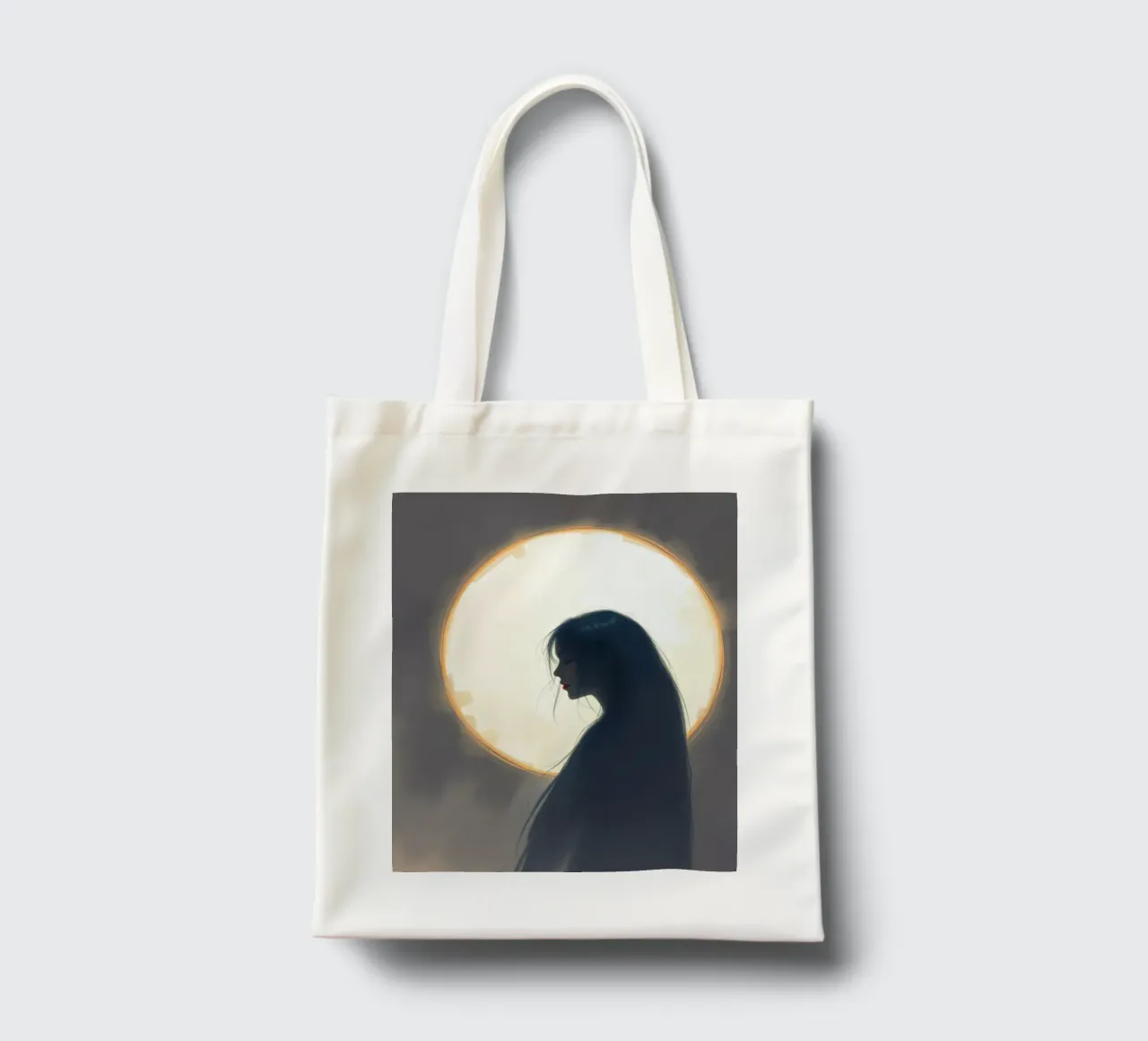 Silueta de una mujer con el pelo largo contra una luna llena tote bag de DesignDoodle