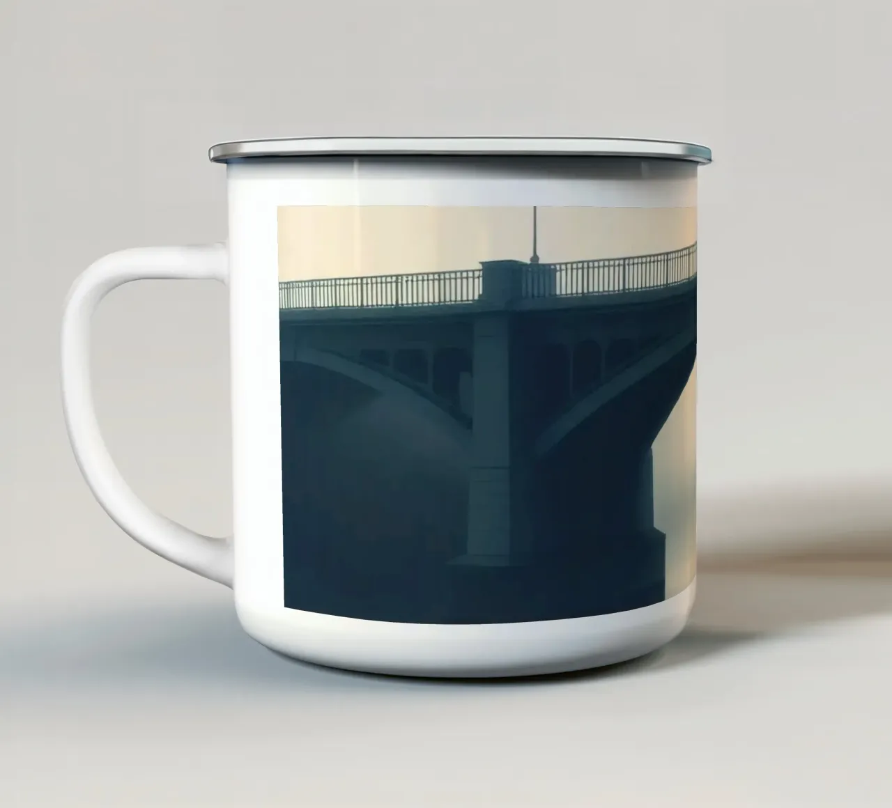 Ponte avvolto dalla nebbia che si riflette sulle acque ferme all'alba tazza in smalto da DesignDoodle