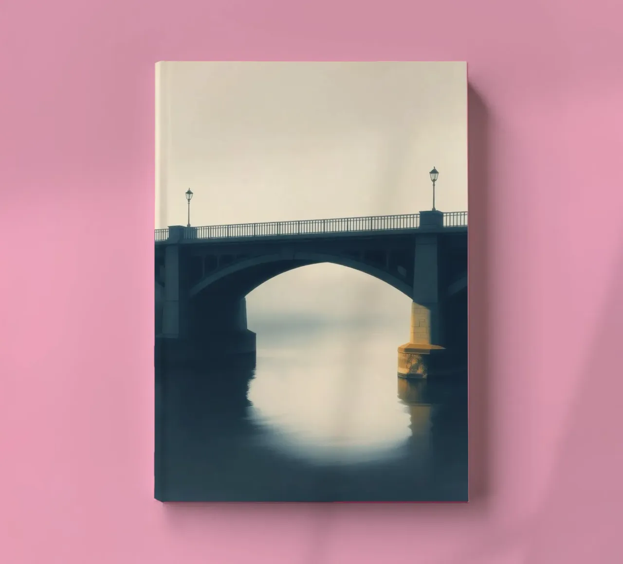 Bridge shrouded in fog reflecting on still waters at dawn notebook by DesignDoodle