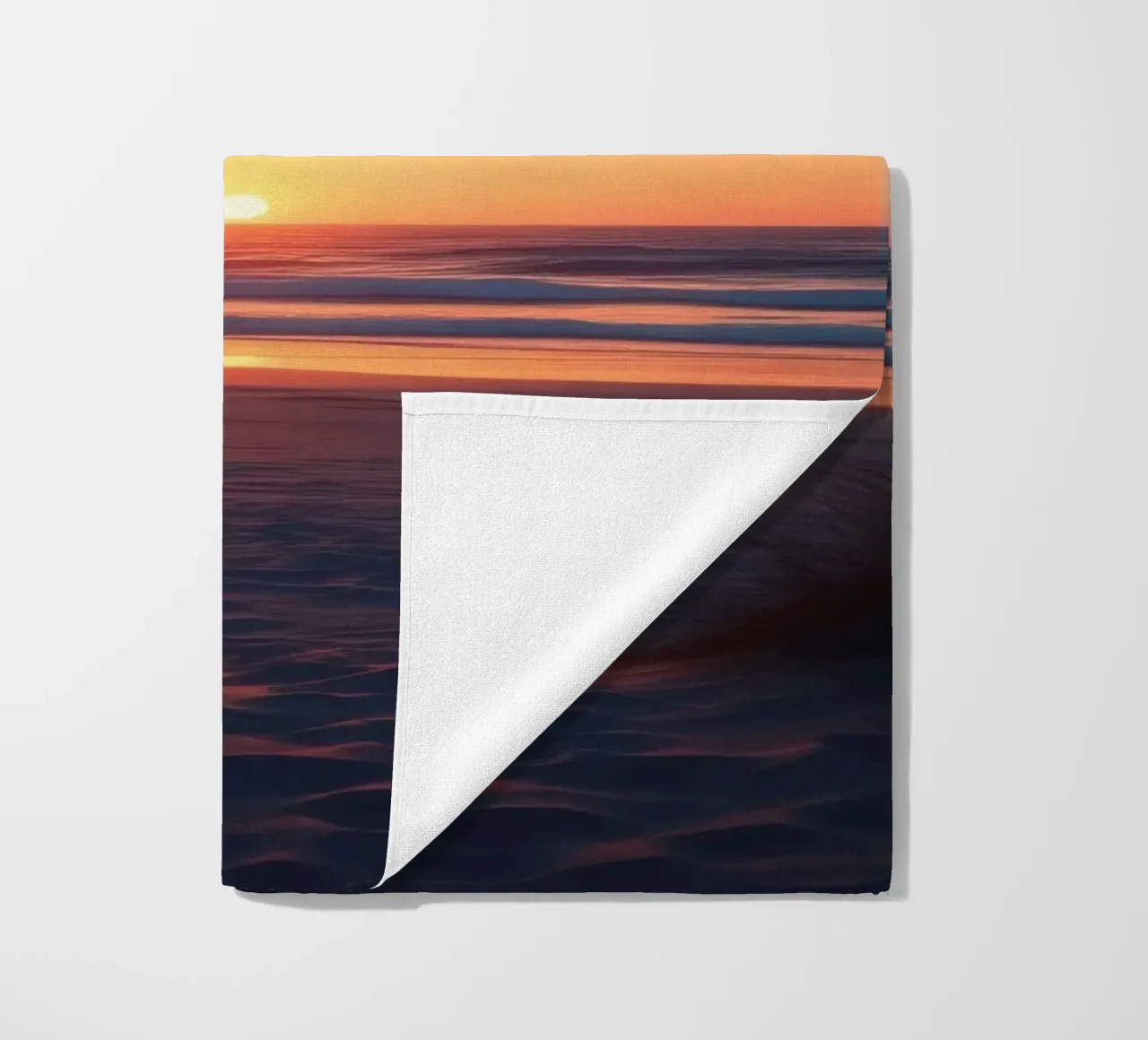 zonsondergang over een rustig strand met zachte golven strandhanddoek van DesignDoodle