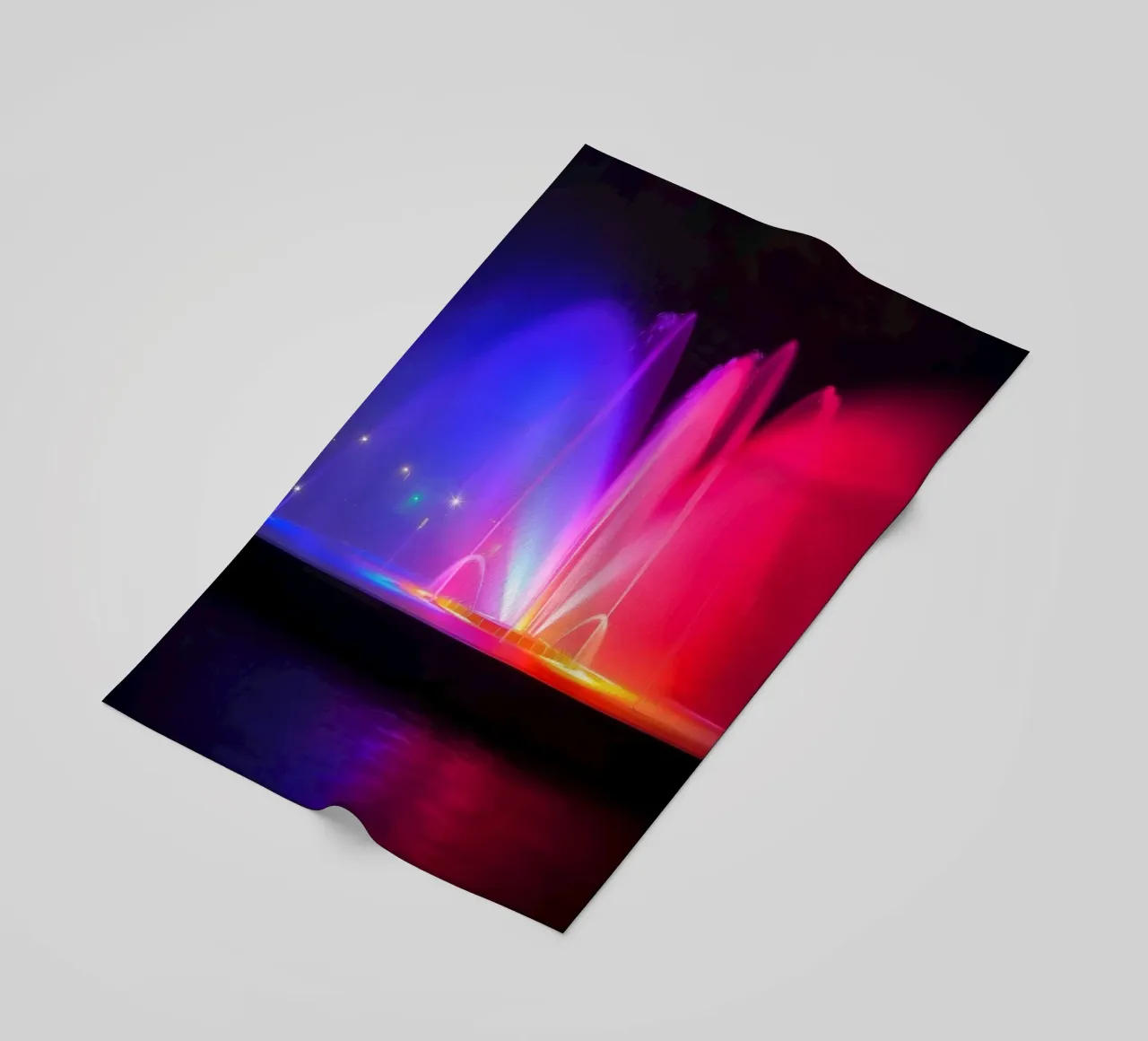 La fontana colorata illumina la notte con una vibrante telo mare da DesignDoodle