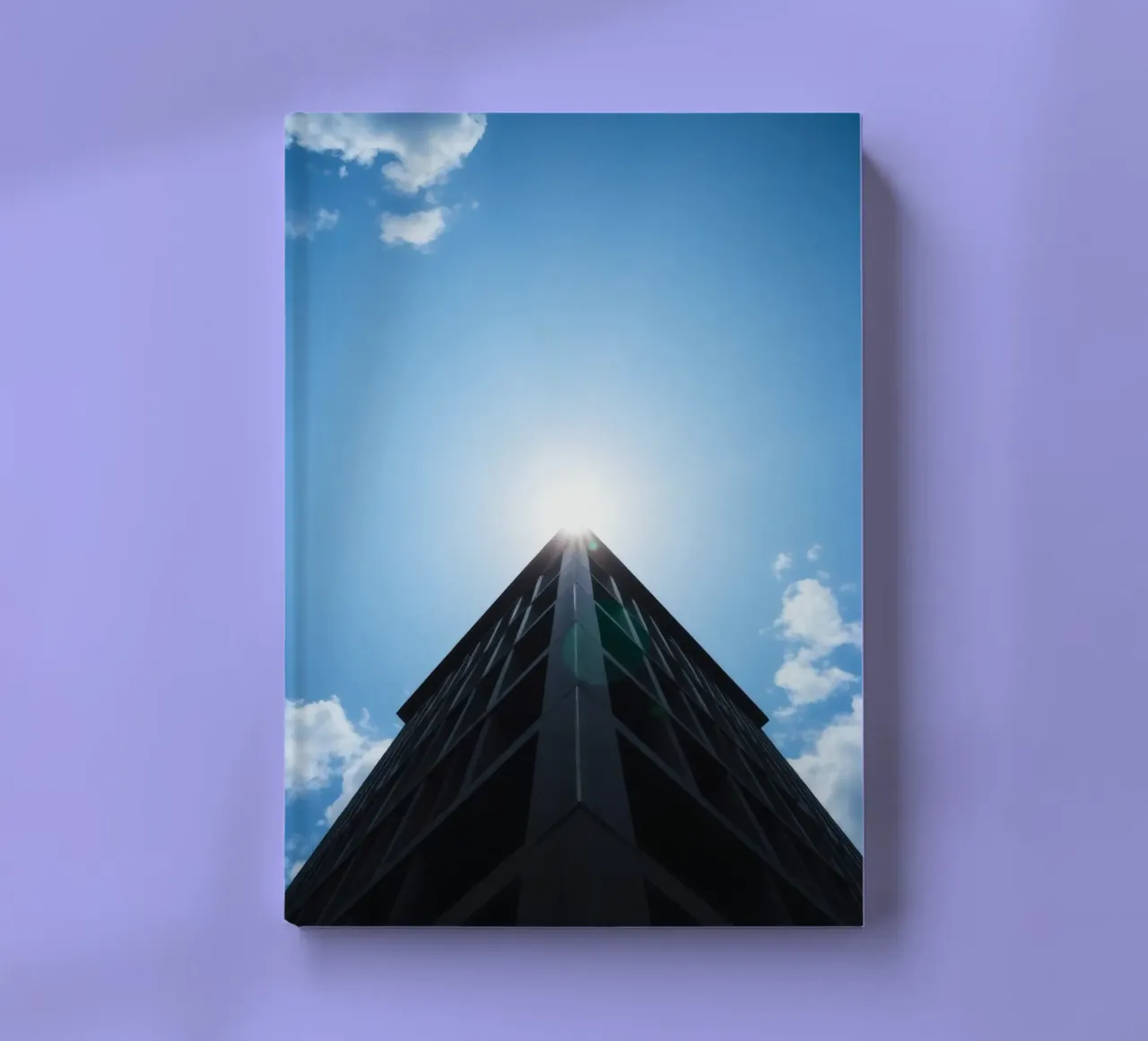 Bright sunlight reflects off the top of a tall building notebook by DesignDoodle