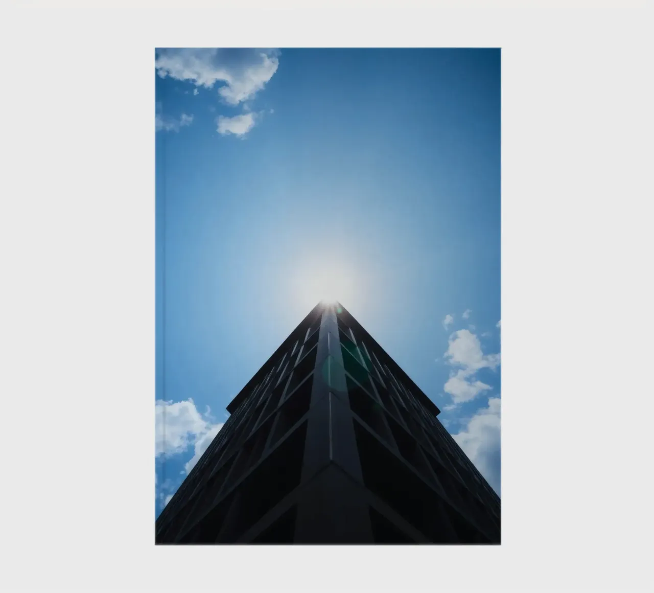 Bright sunlight reflects off the top of a tall building notebook by DesignDoodle