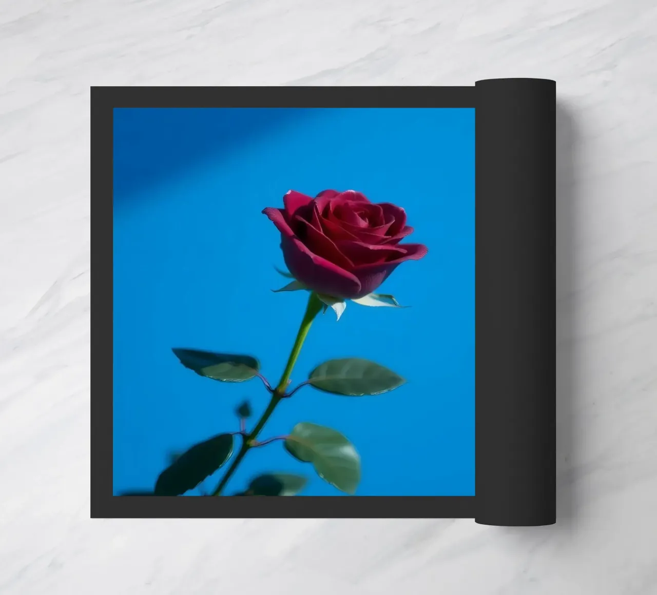 Une rose rouge vif s'épanouit sur un fond bleu vif. paillasson de DesignDoodle