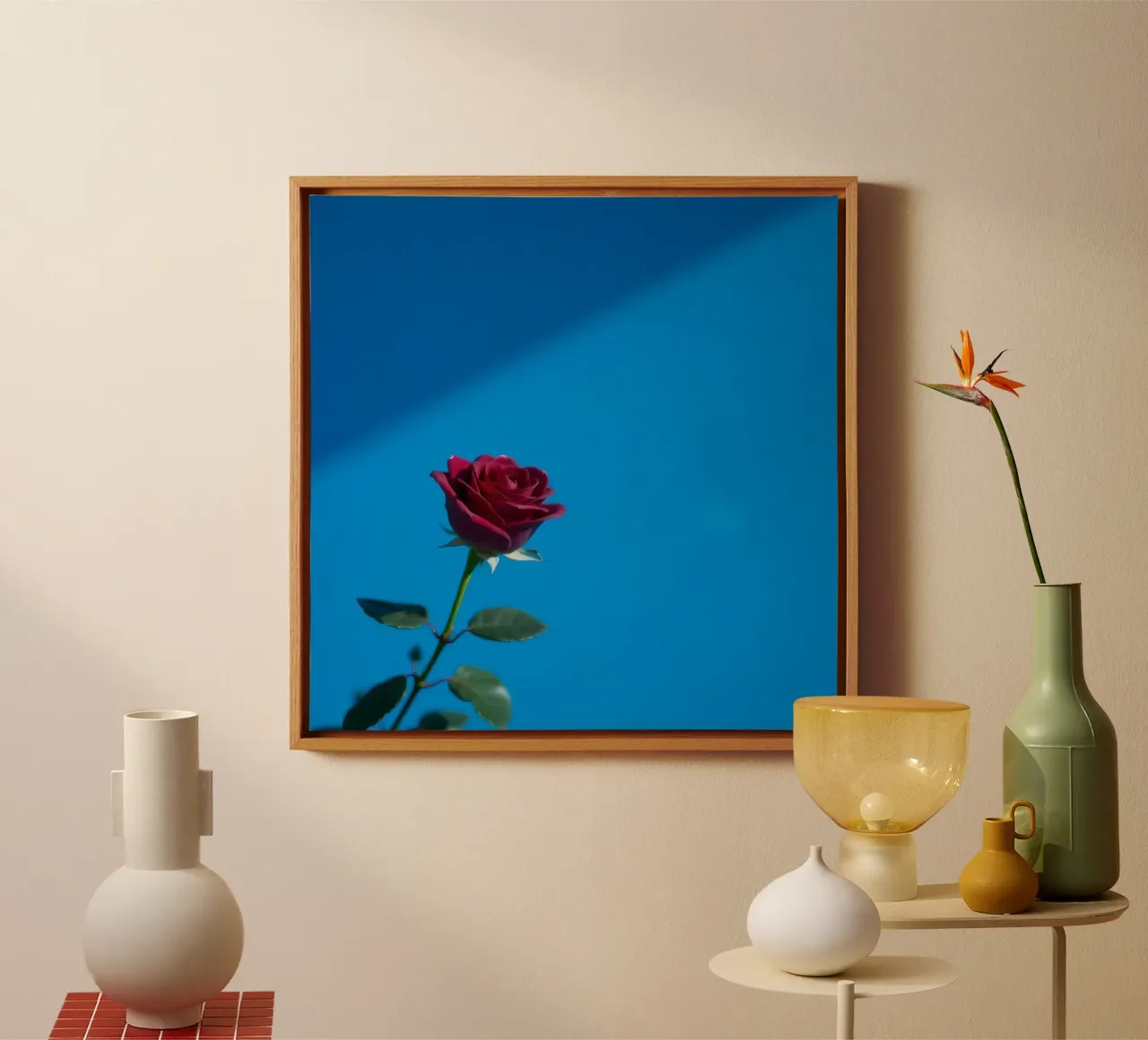 Une rose rouge vif s'épanouit sur un fond bleu vif. toile de DesignDoodle