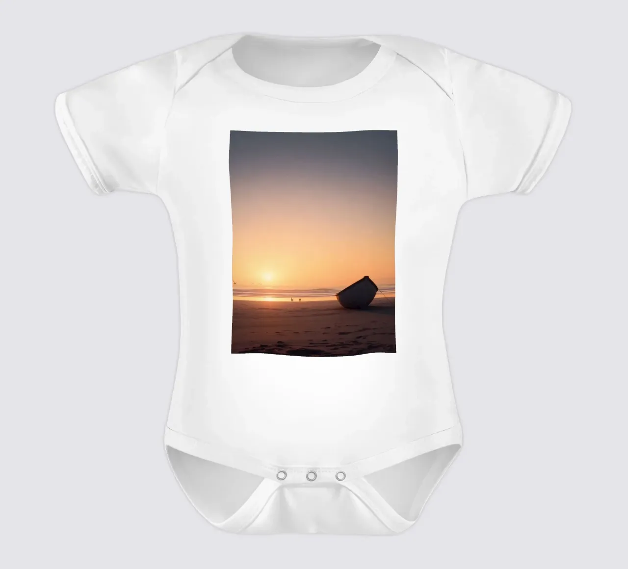 Sunset view with a lone boat on a tranquil beach showcasing short-sleeve baby romper by DesignDoodle