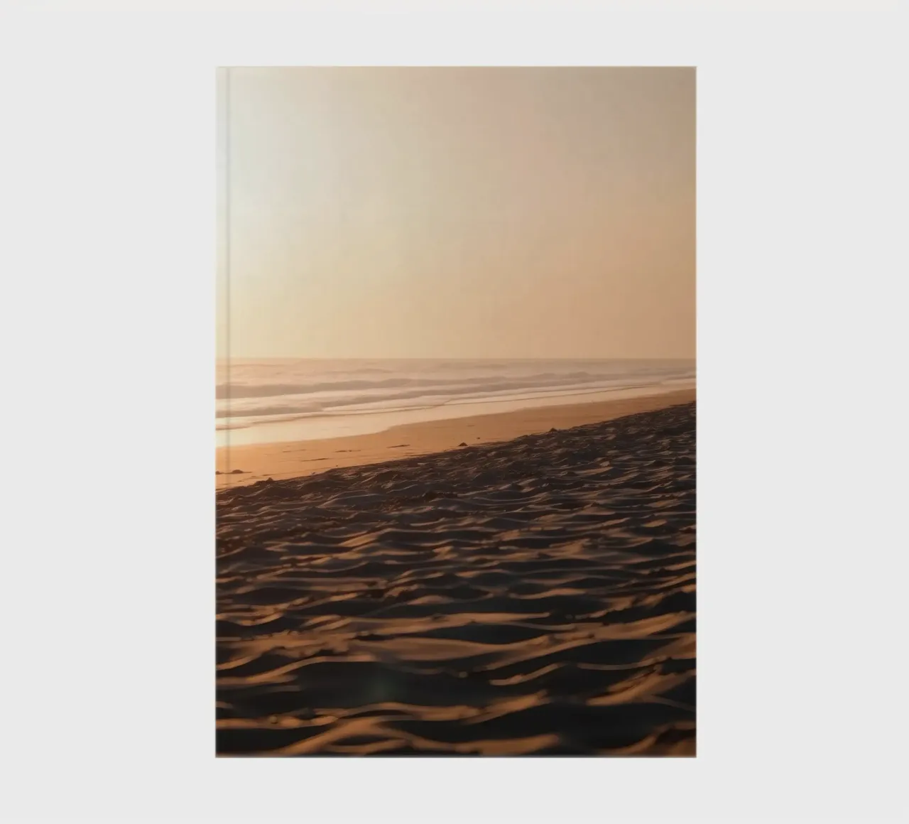 Golden sunset over tranquil beach with gentle waves and soft notebook by DesignDoodle