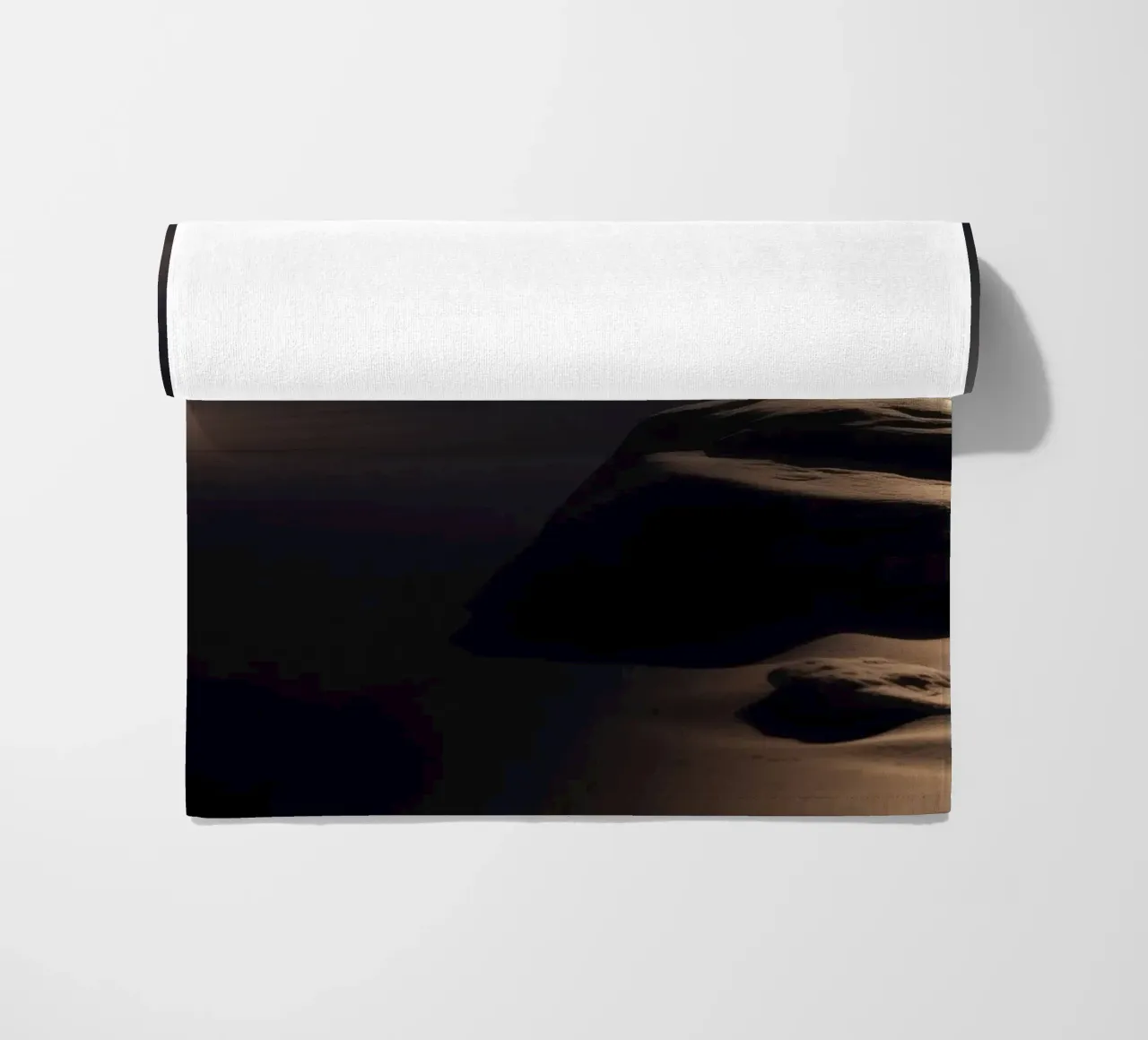 Fasci di luce illuminano una roccia solitaria su una spiaggia scura e sabbiosa telo mare da DesignDoodle