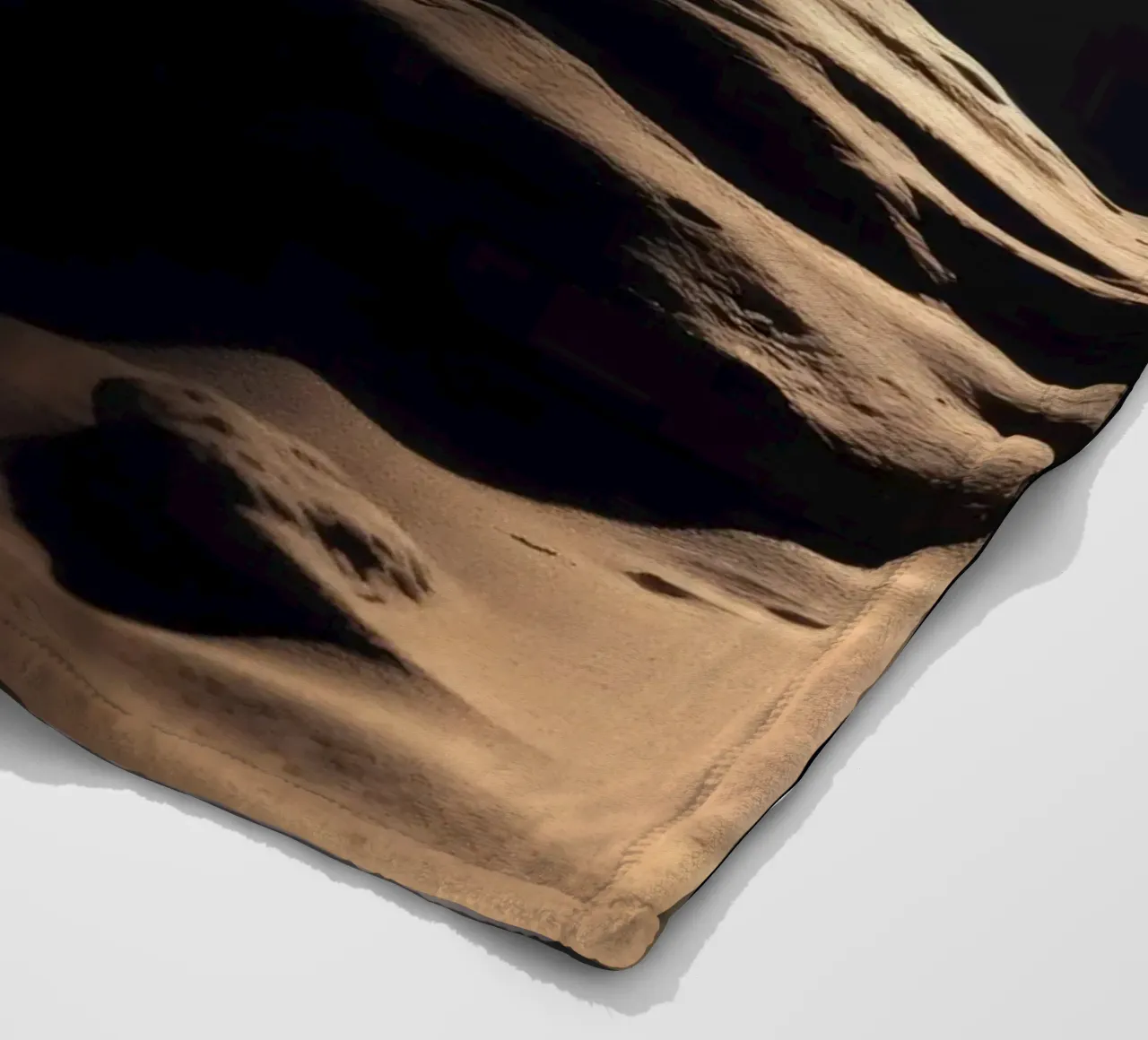 Fasci di luce illuminano una roccia solitaria su una spiaggia scura e sabbiosa coperta in pile da DesignDoodle