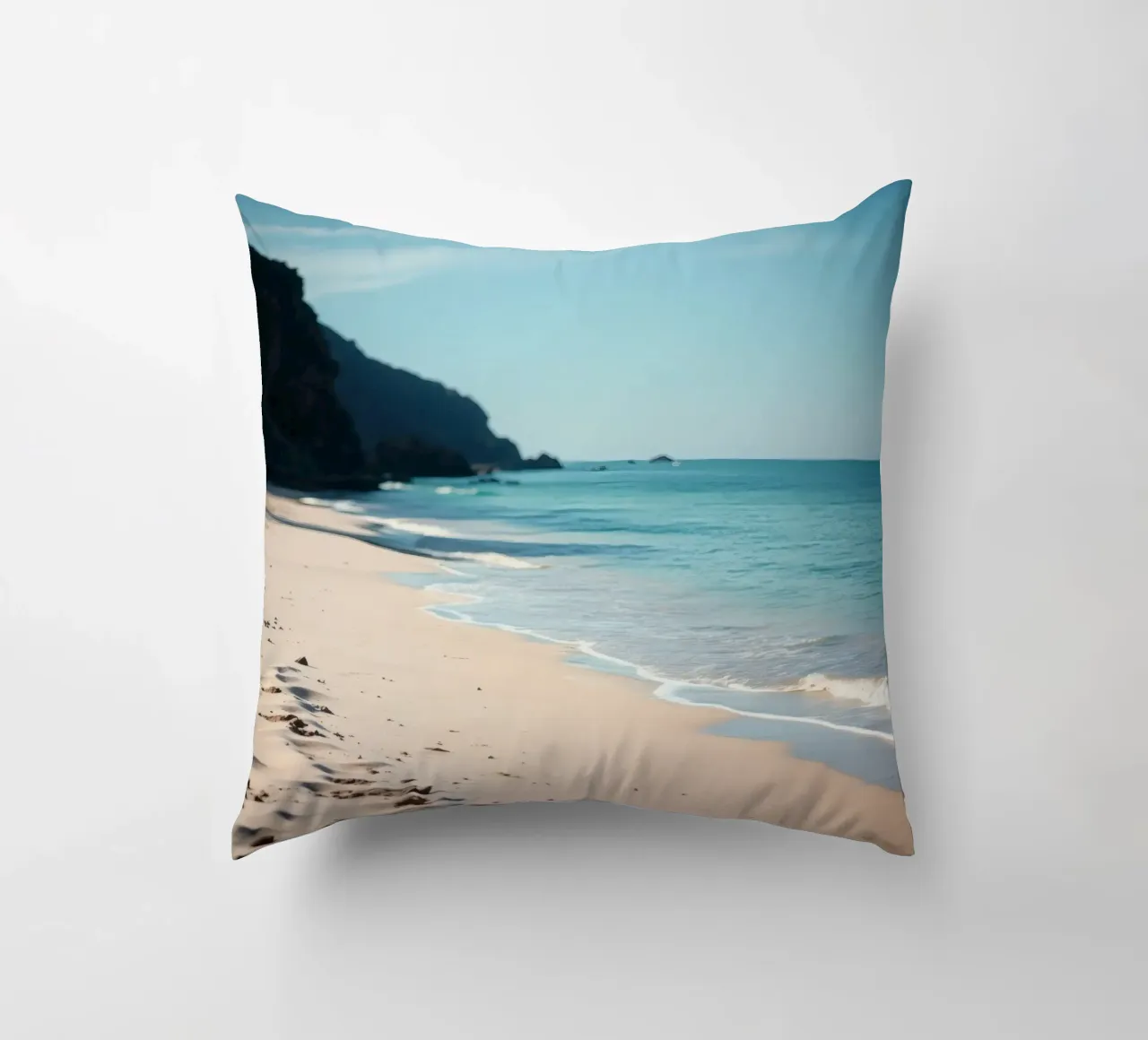 Serene coastline with soft waves lapping against pristine decorative cushion by DesignDoodle