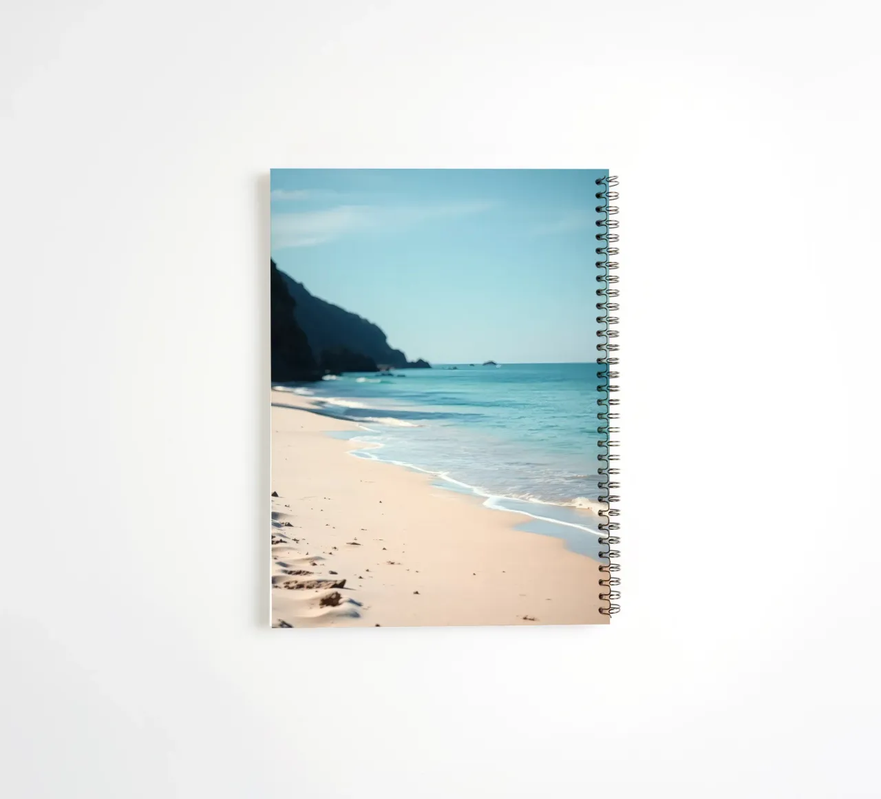 Serene coastline with soft waves lapping against pristine spiral notebook by DesignDoodle