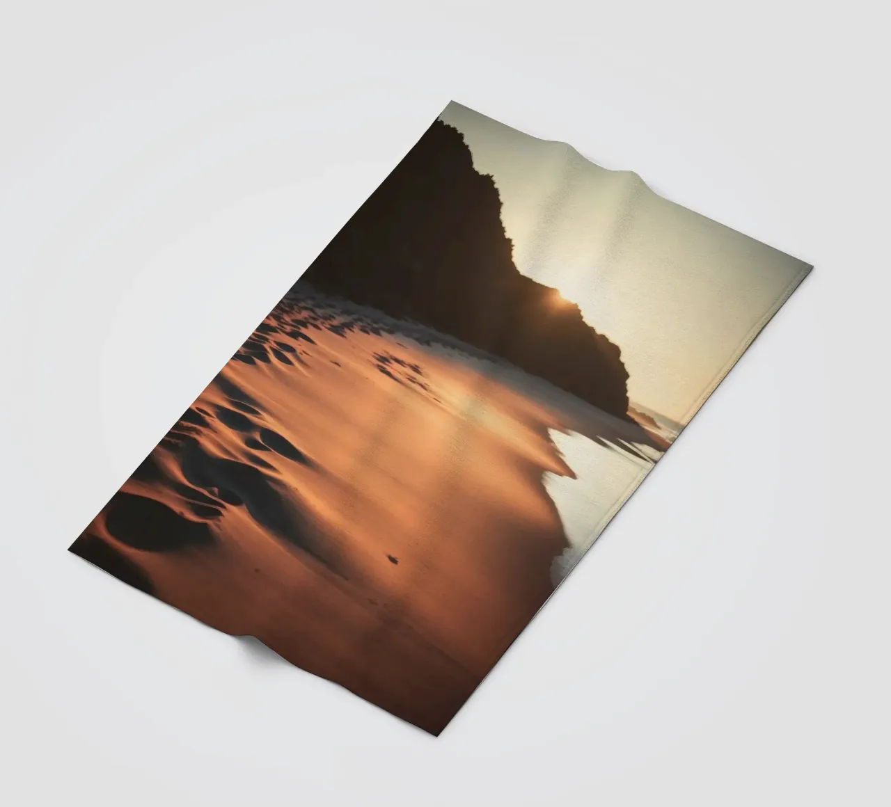 Sunset casts warm glow on sandy beach with gentle waves fleece blanket by DesignDoodle