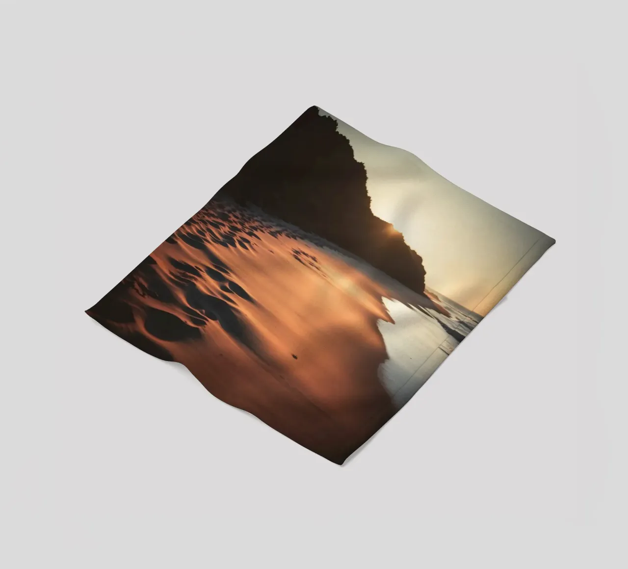 Sunset casts warm glow on sandy beach with gentle waves fleece blanket by DesignDoodle