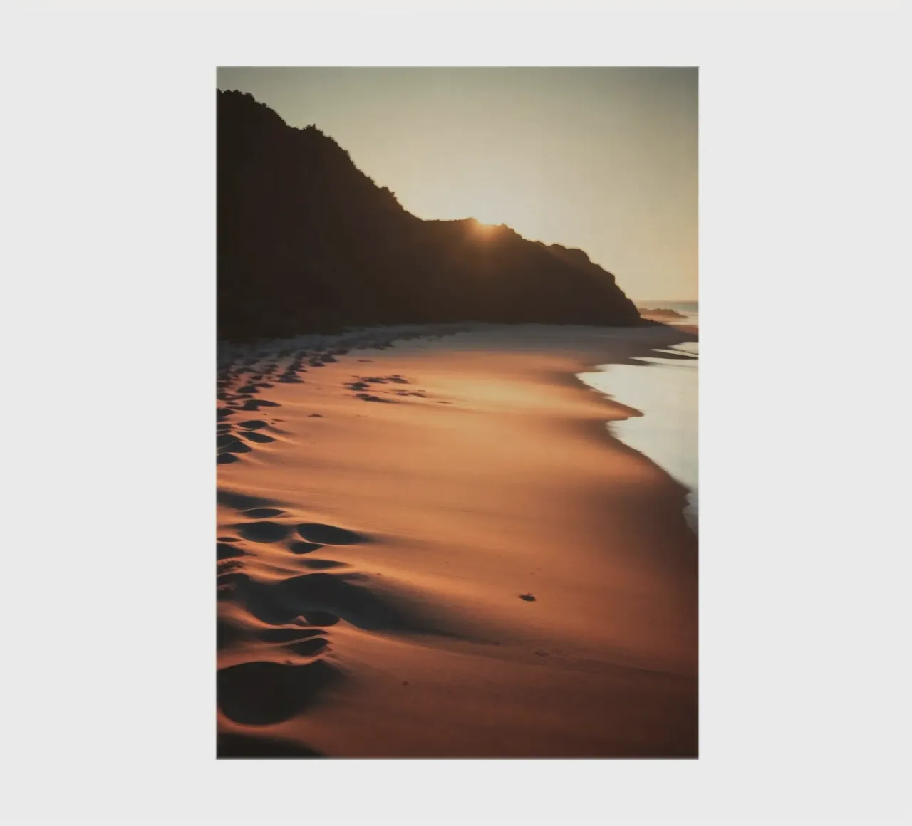 Sunset casts warm glow on sandy beach with gentle waves notebook by DesignDoodle