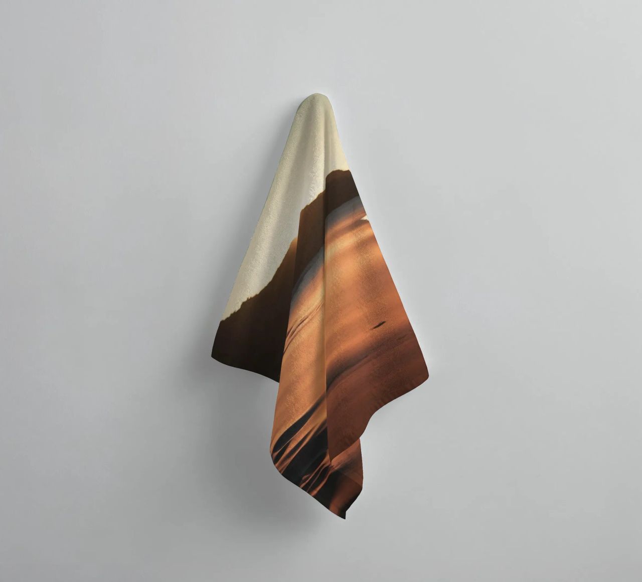 Zonsondergang werpt warme gloed op zandstrand met zachte golven badhanddoek van DesignDoodle