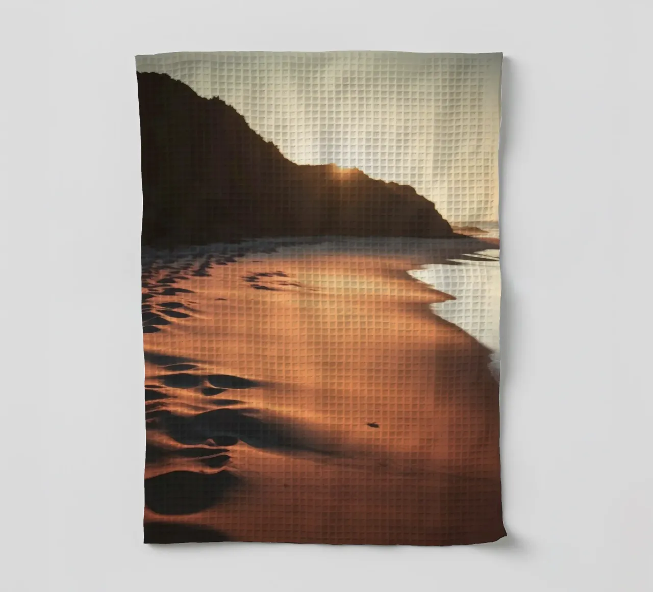 Le coucher de soleil jette une lumière chaude sur une plage de sable avec de douces vagues. torchon de DesignDoodle