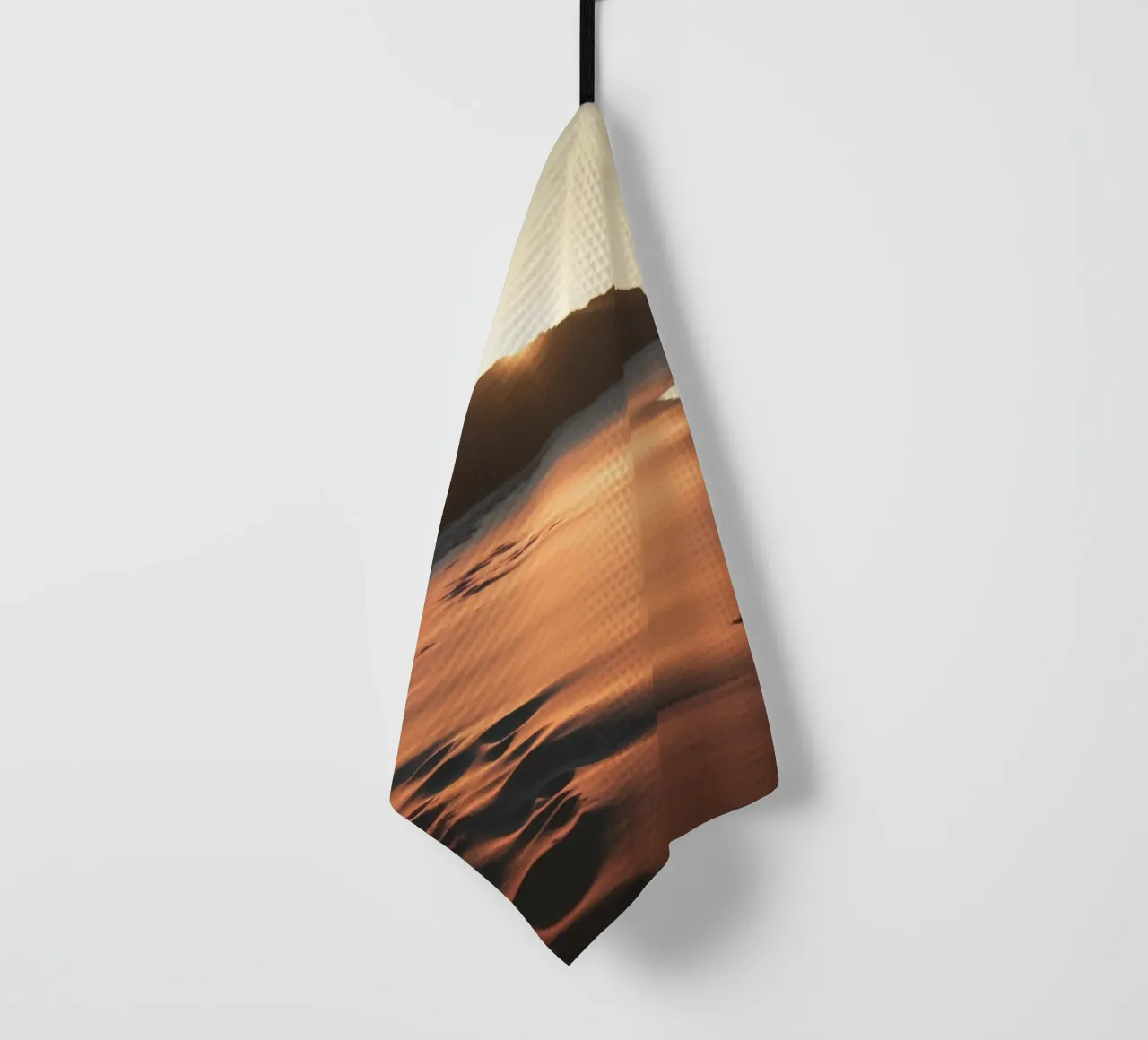 Le coucher de soleil jette une lumière chaude sur une plage de sable avec de douces vagues. torchon de DesignDoodle
