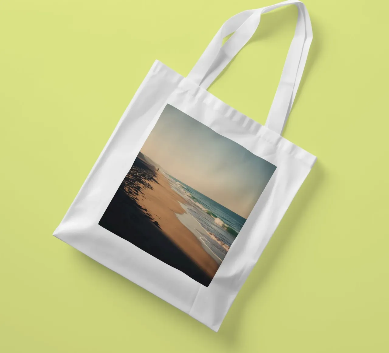 Serene beach view at sunset with gentle waves lapping tote bag by DesignDoodle