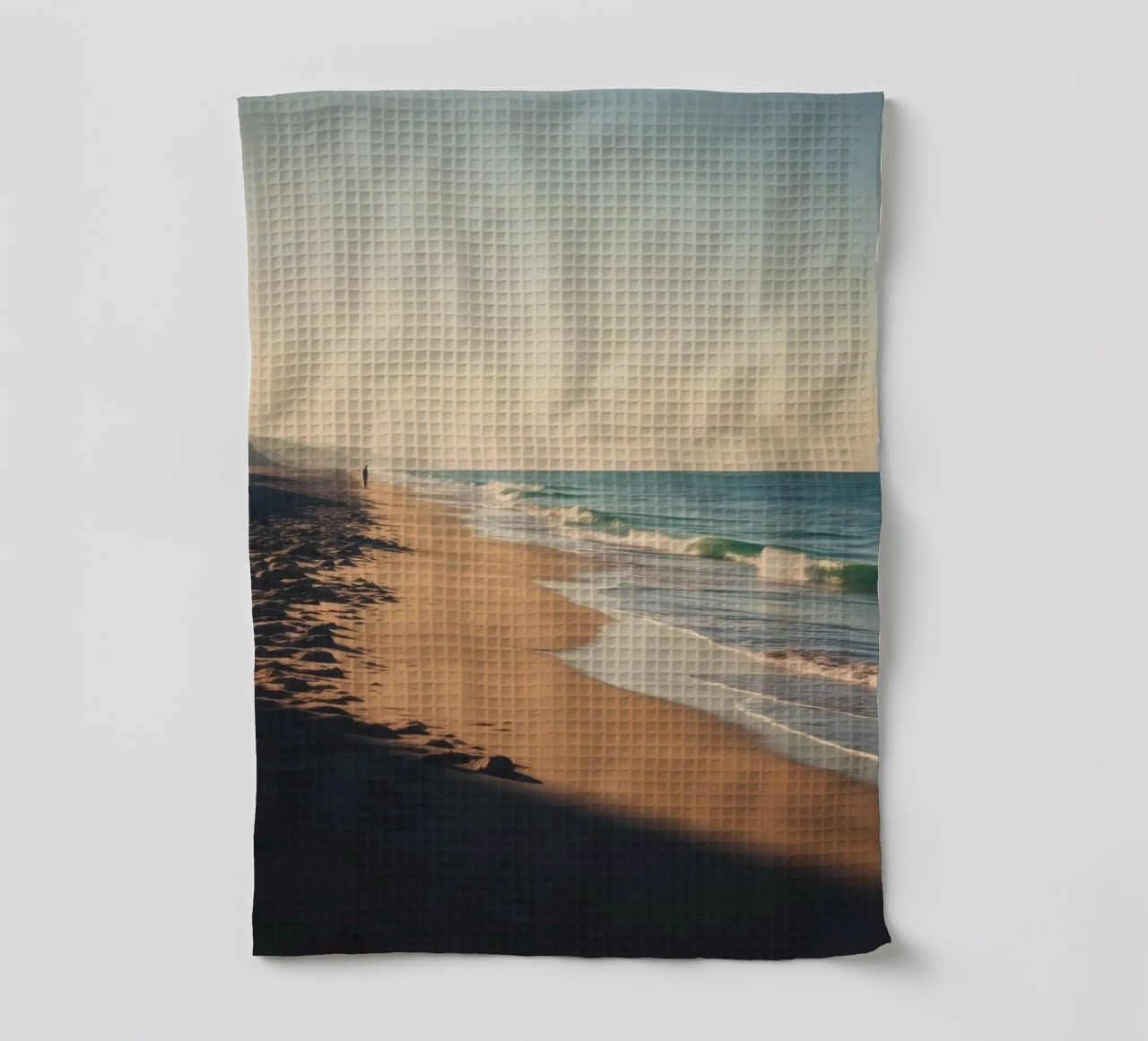 Vue sereine sur la plage au coucher du soleil avec le clapotis des vagues torchon de DesignDoodle