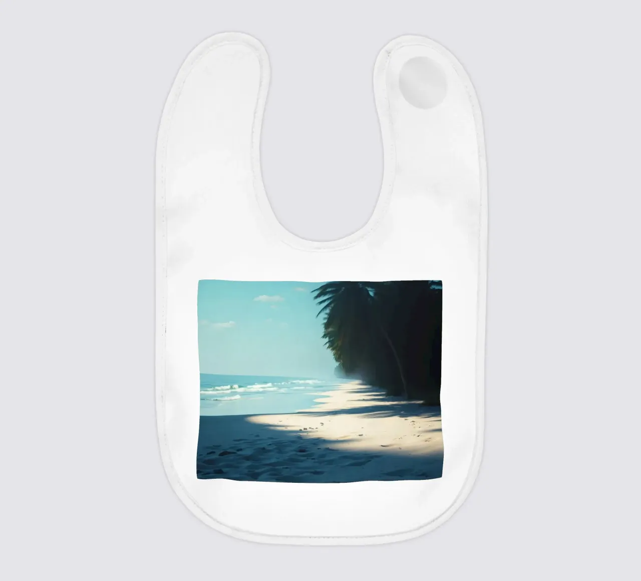 Serene beach with palm trees and gentle waves under a clear baby bib by DesignDoodle