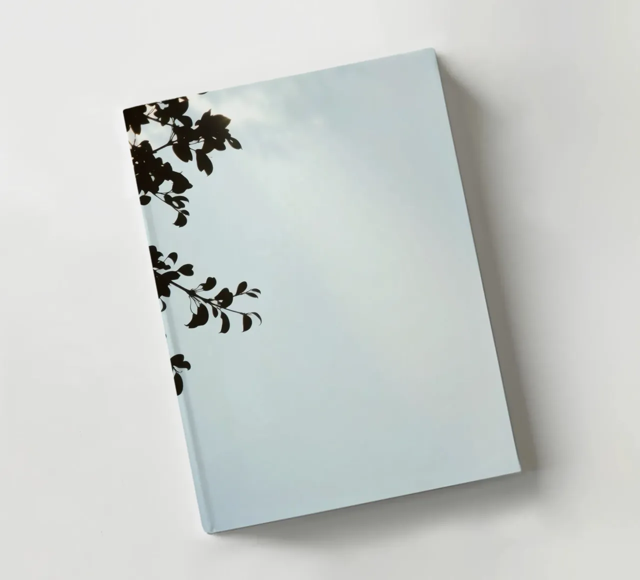 Clear blue sky with leafy branches contrasting notebook by DesignDoodle