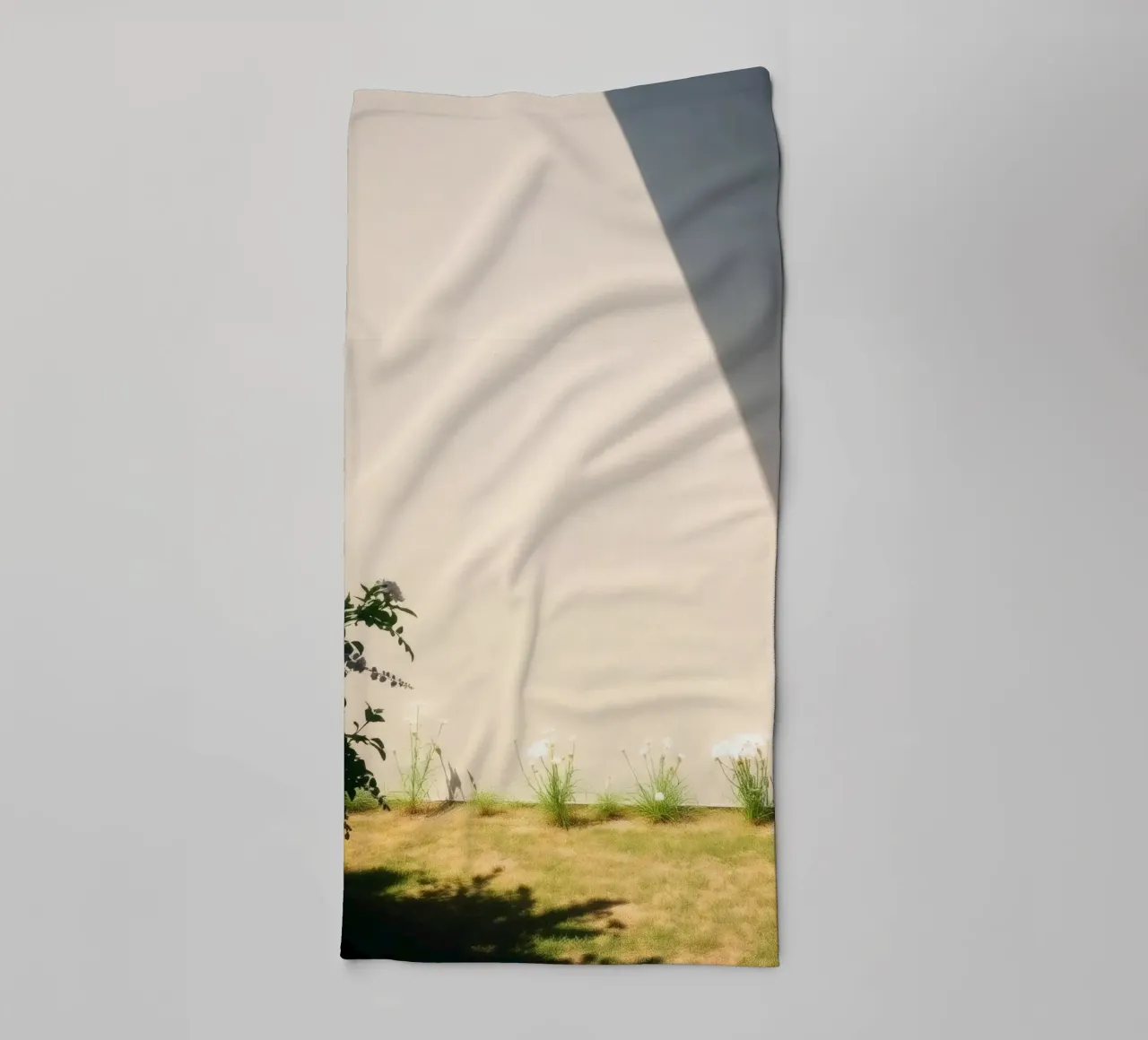 Zonlicht werpt dramatische schaduwen op een tuin met bloeiende bloemen badhanddoek van DesignDoodle
