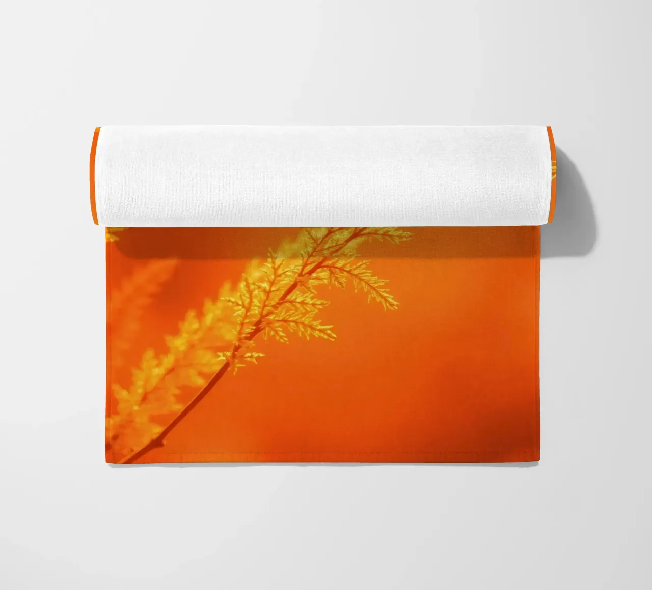 Vibrant golden background with delicate foliage illuminated beach towel by DesignDoodle
