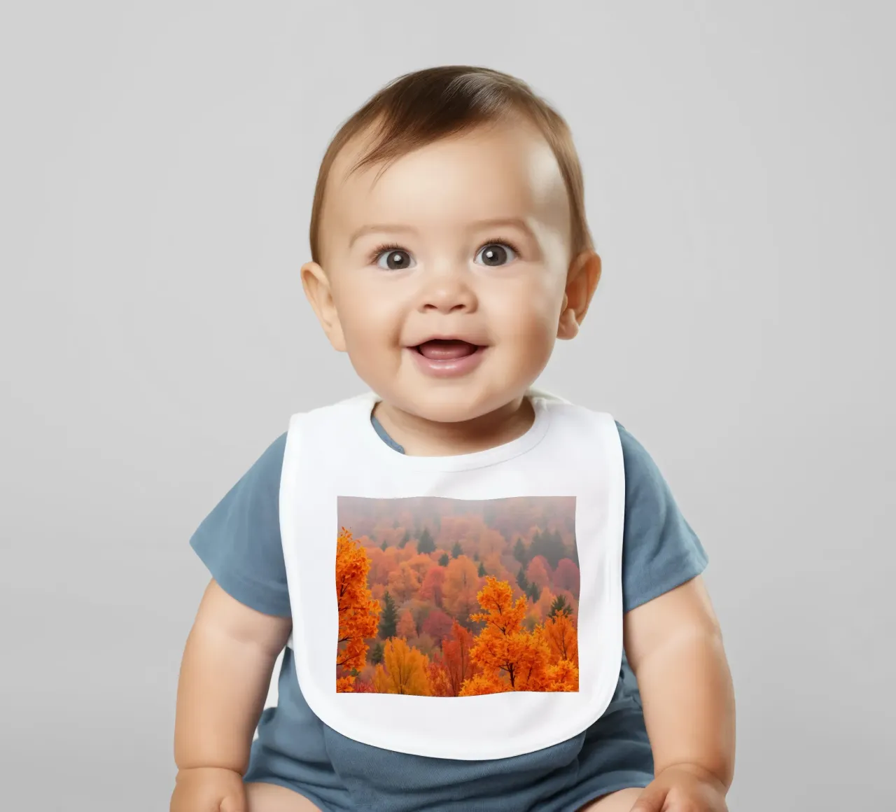 fall foliage creating a stunning backdrop in a misty forest baby bib by DesignDoodle