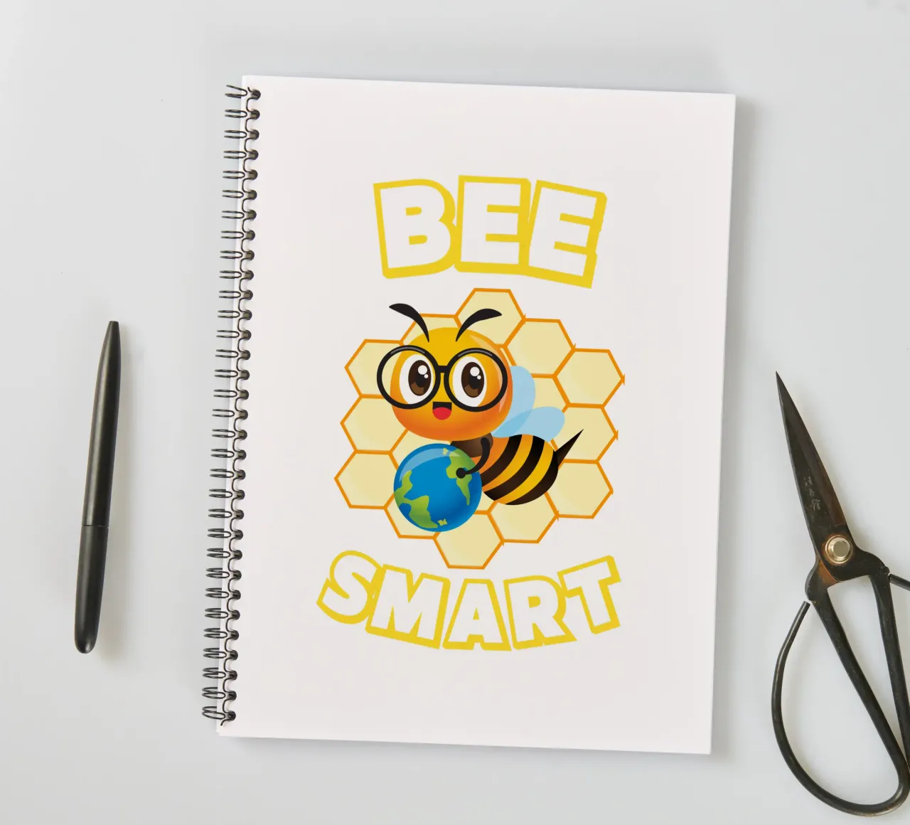 Bee with glasses and globe in front of yellow honeycomb spiral notebook by ArtDesign by KBK