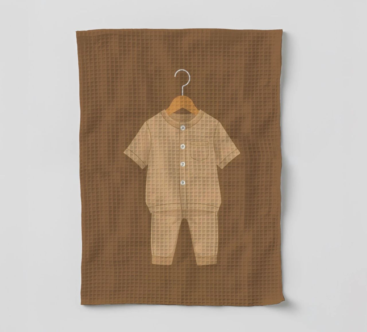 Un joli ensemble beige pour enfant suspendu à un cintre en bois. torchon de DesignDoodle