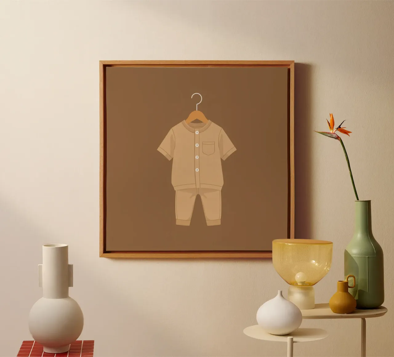Un grazioso completino beige per bambini appeso ad una gruccia di legno ag tela con Cornice a cassetta da DesignDoodle