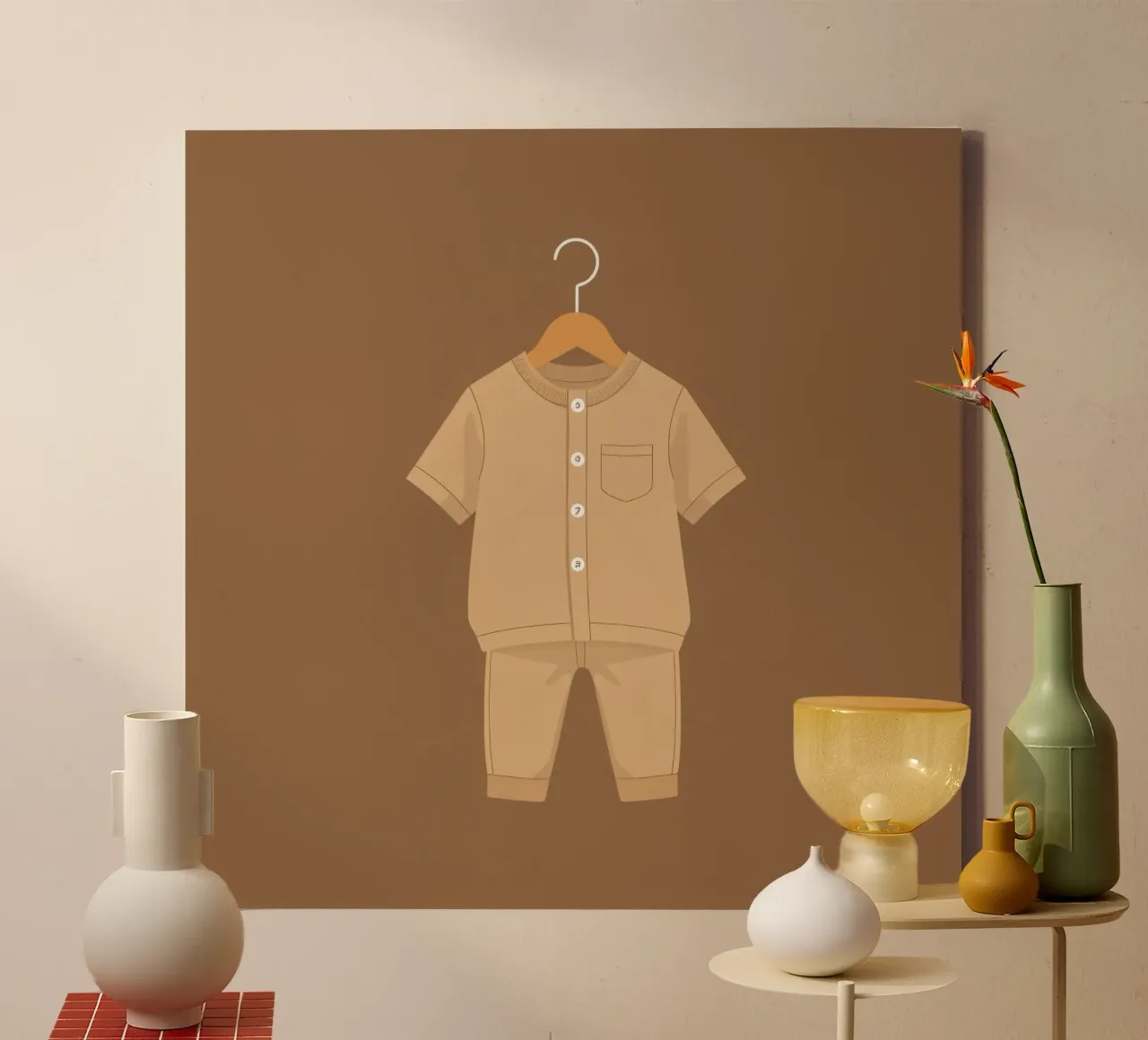 Un grazioso completino beige per bambini appeso ad una gruccia di legno ag tela con Cornice a cassetta da DesignDoodle