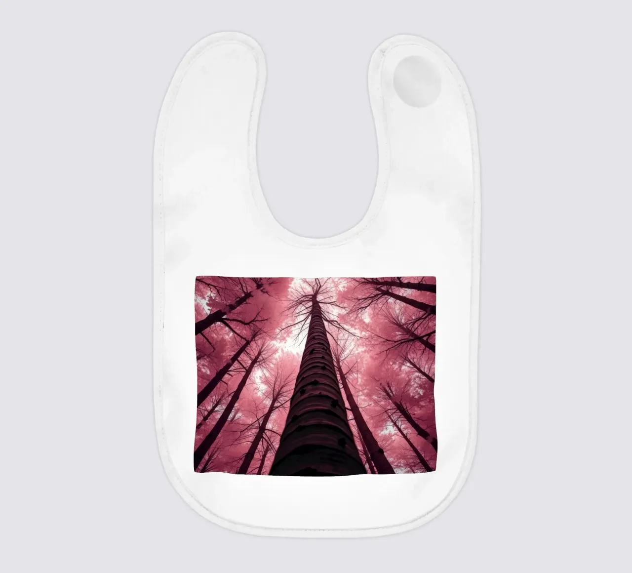 Tall trees stretch towards a pink sky creating a dreamy baby bib by DesignDoodle