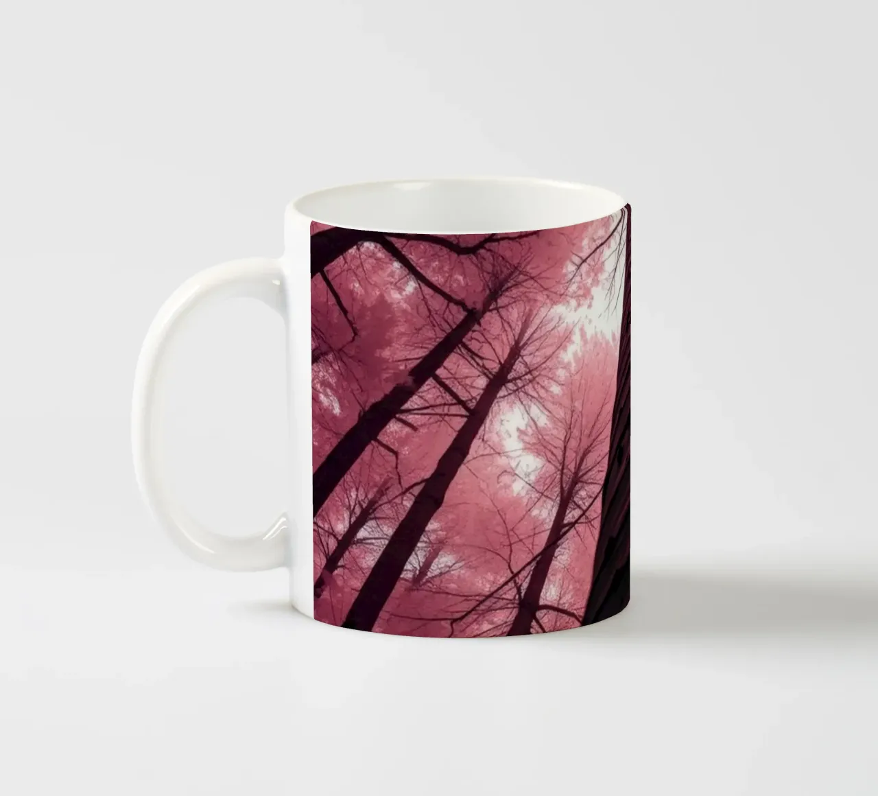 Gli alti alberi si protendono verso il cielo rosa creando un'atmosfera da sogno. tazza in ceramica da DesignDoodle