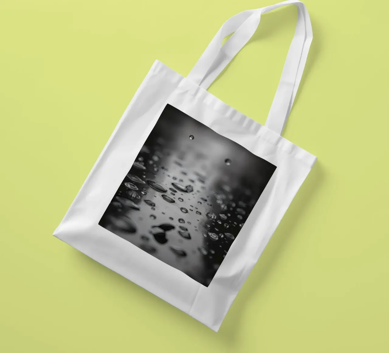 Raindrops creating reflections on a wet surface tote bag by DesignDoodle