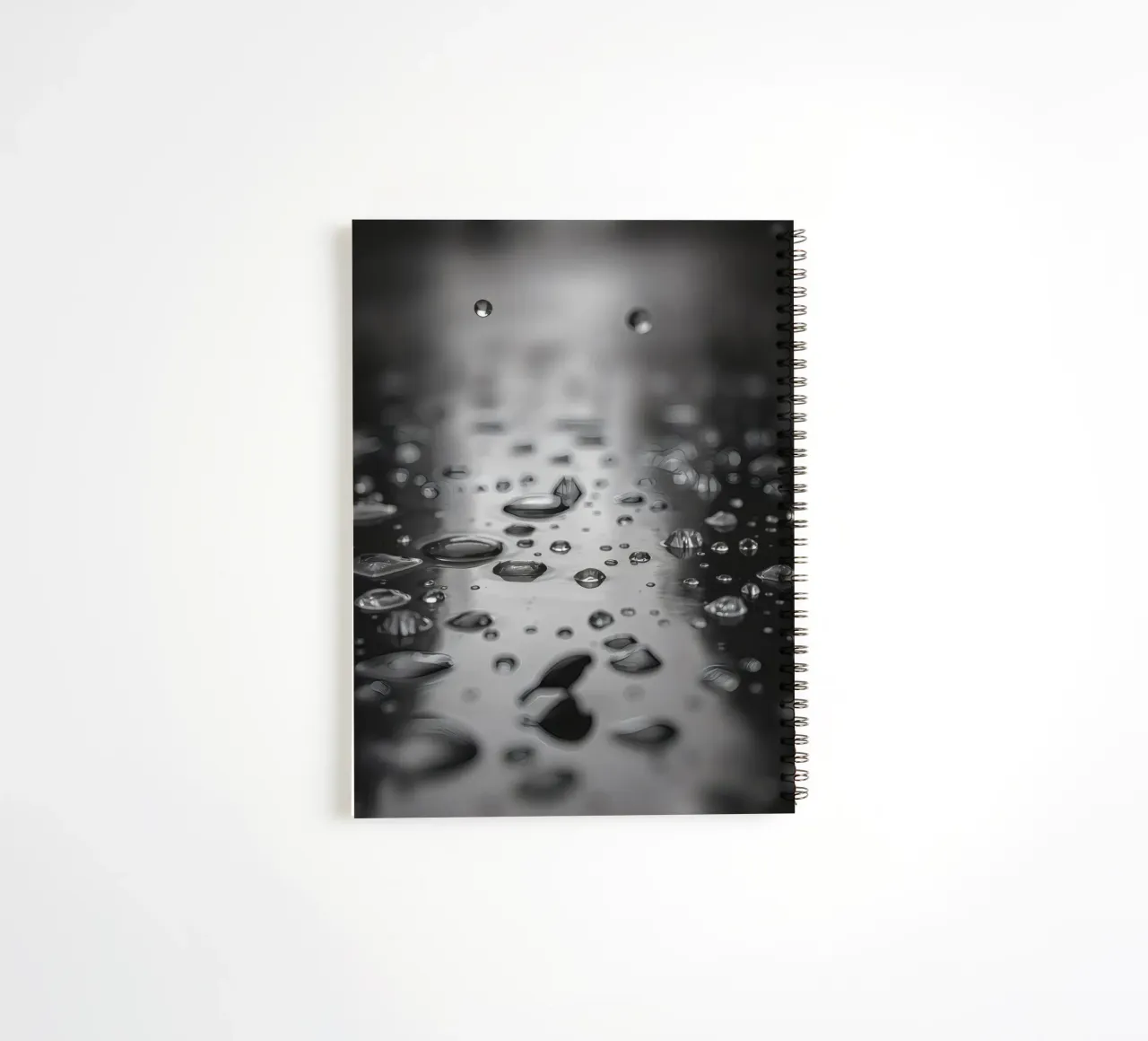 Raindrops creating reflections on a wet surface spiral notebook by DesignDoodle