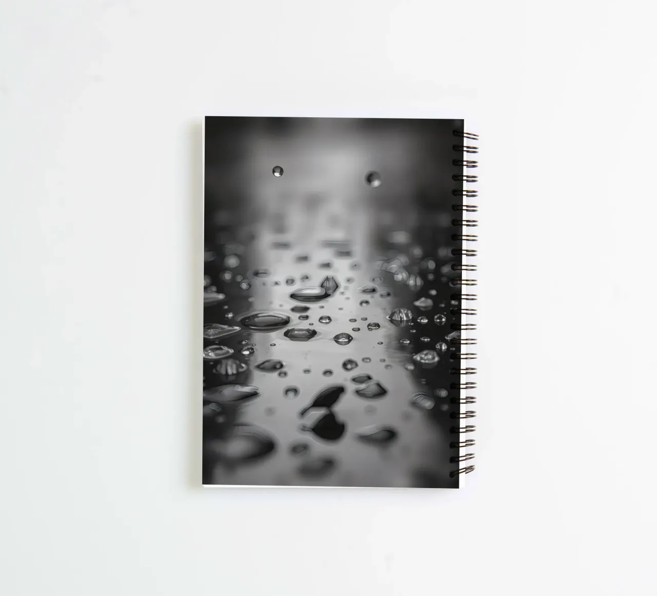 Raindrops creating reflections on a wet surface spiral notebook by DesignDoodle