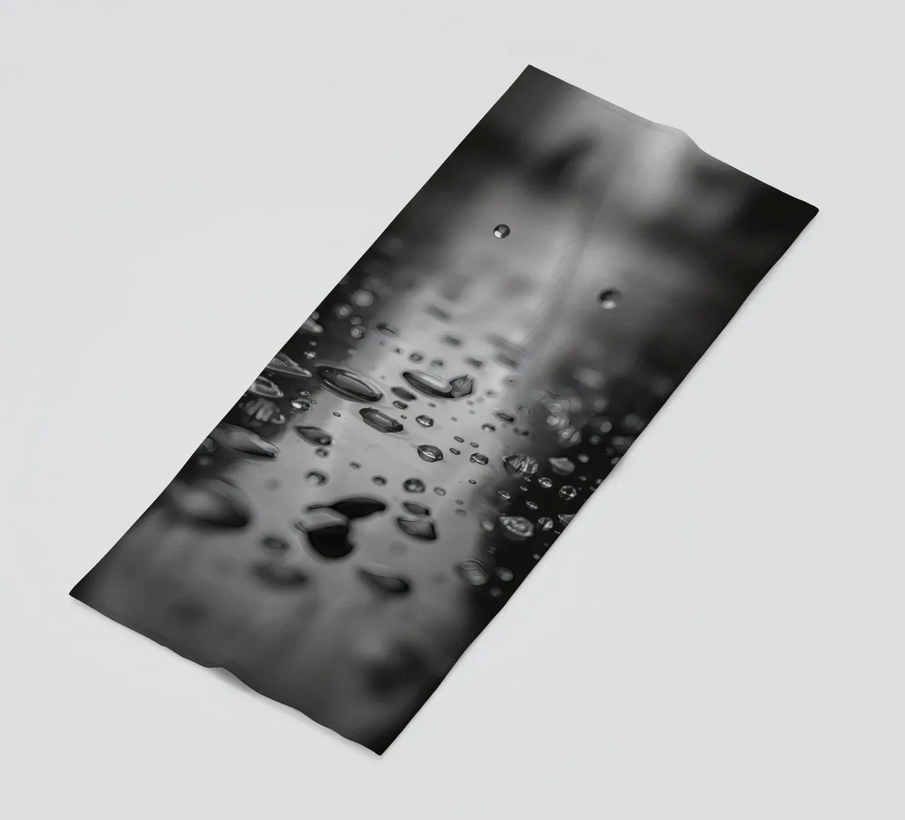 Raindrops creating reflections on a wet surface beach towel by DesignDoodle